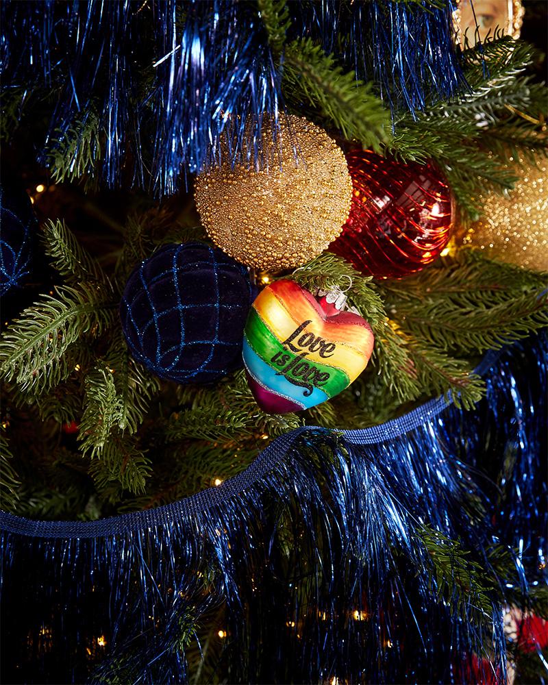 A gift bag with a Christmas design, decorated with a star, lametta