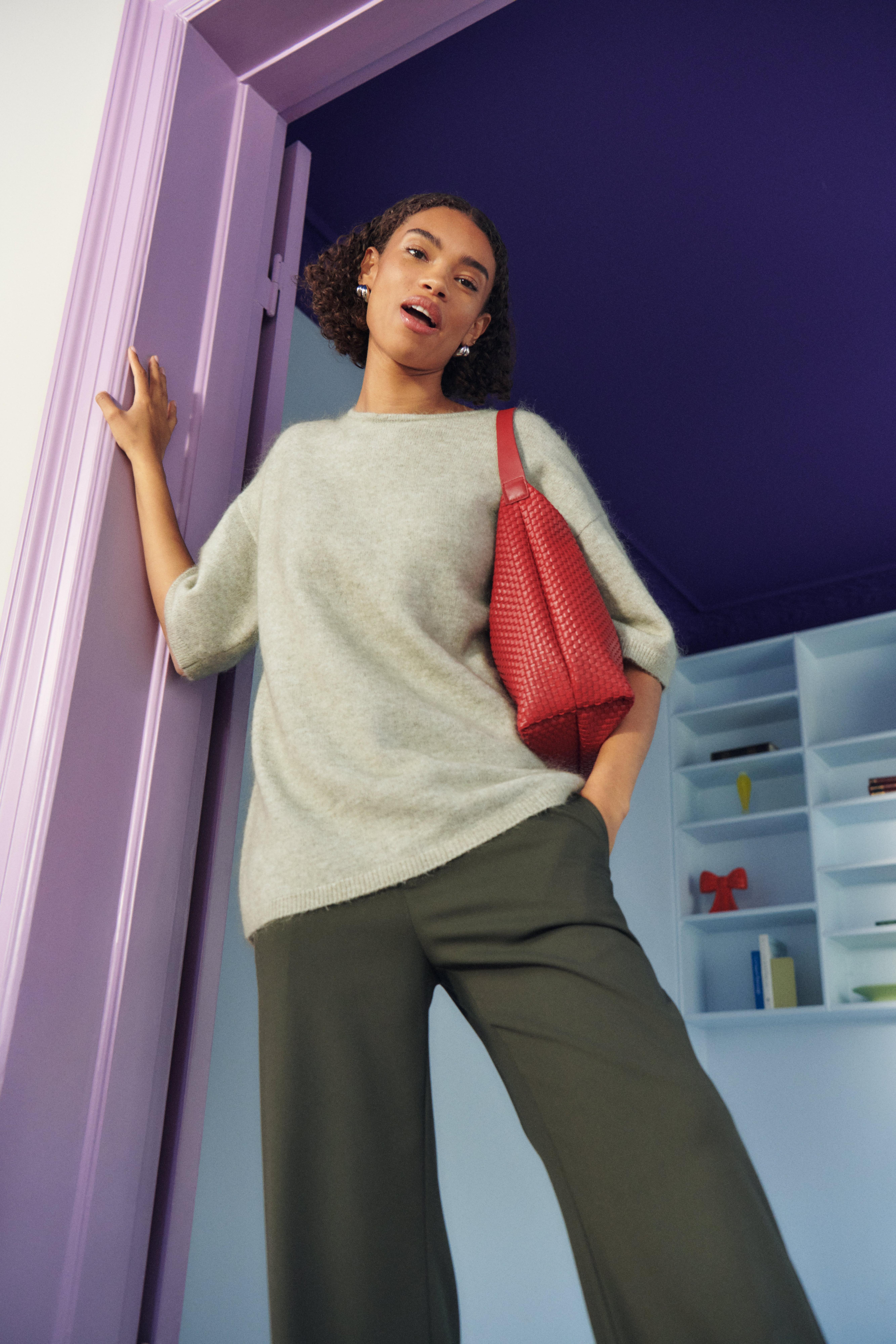Woman in grey shirt and red bag