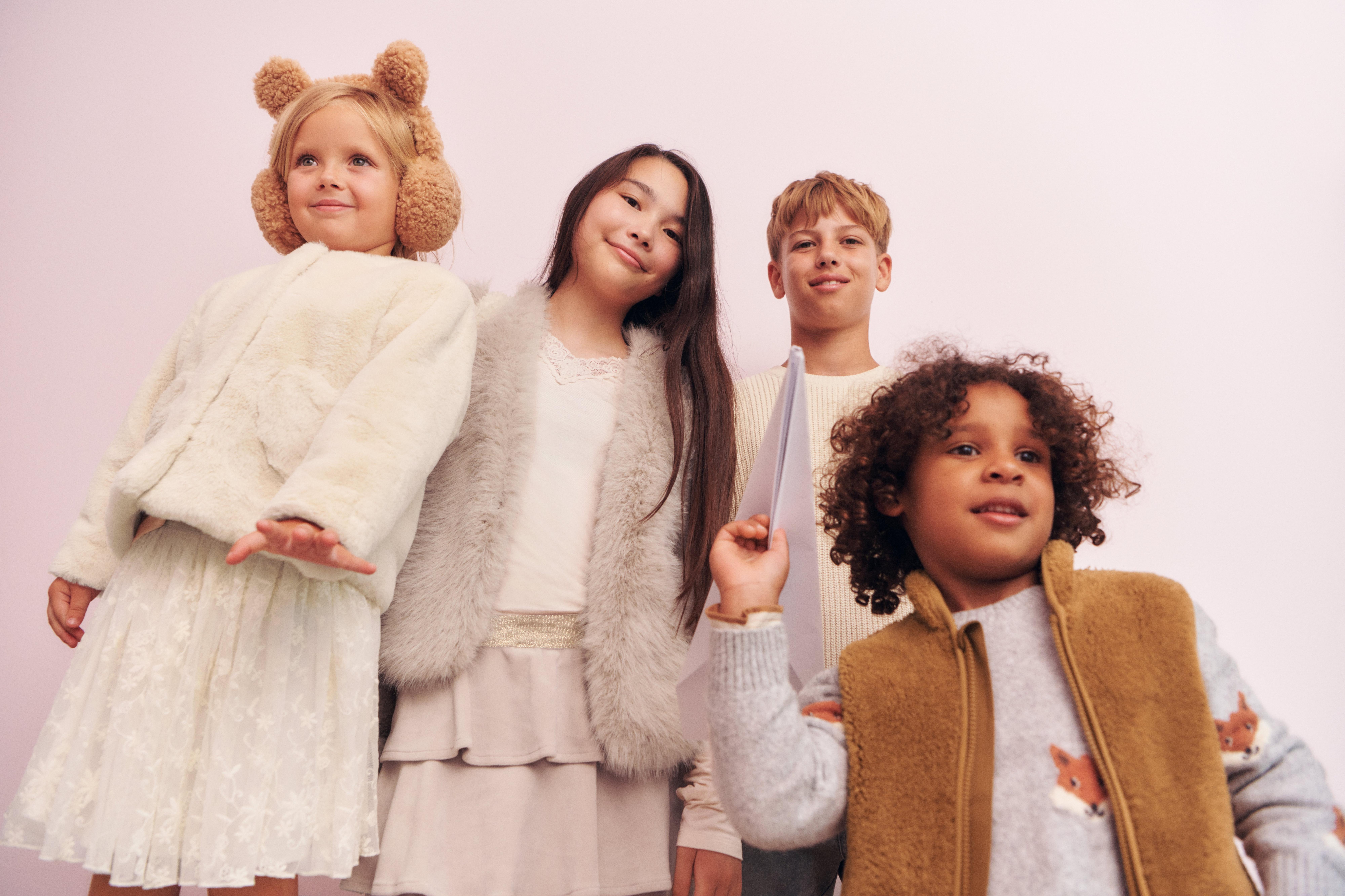 A boy standing on a beach, he´s holding a ice cream cone over his head screaming of joy..
