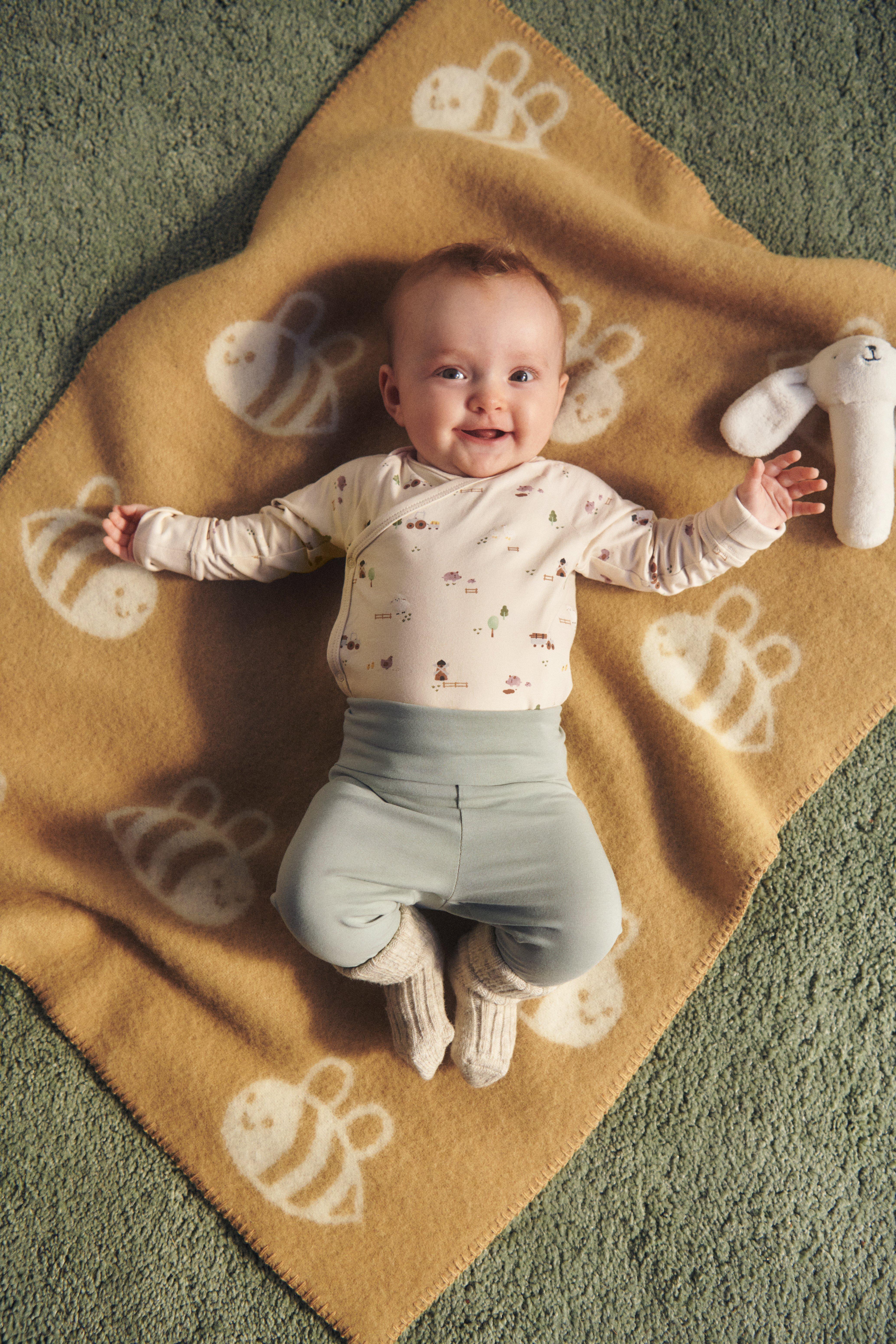  A close-up of a baby dressed in a baby starter kit.