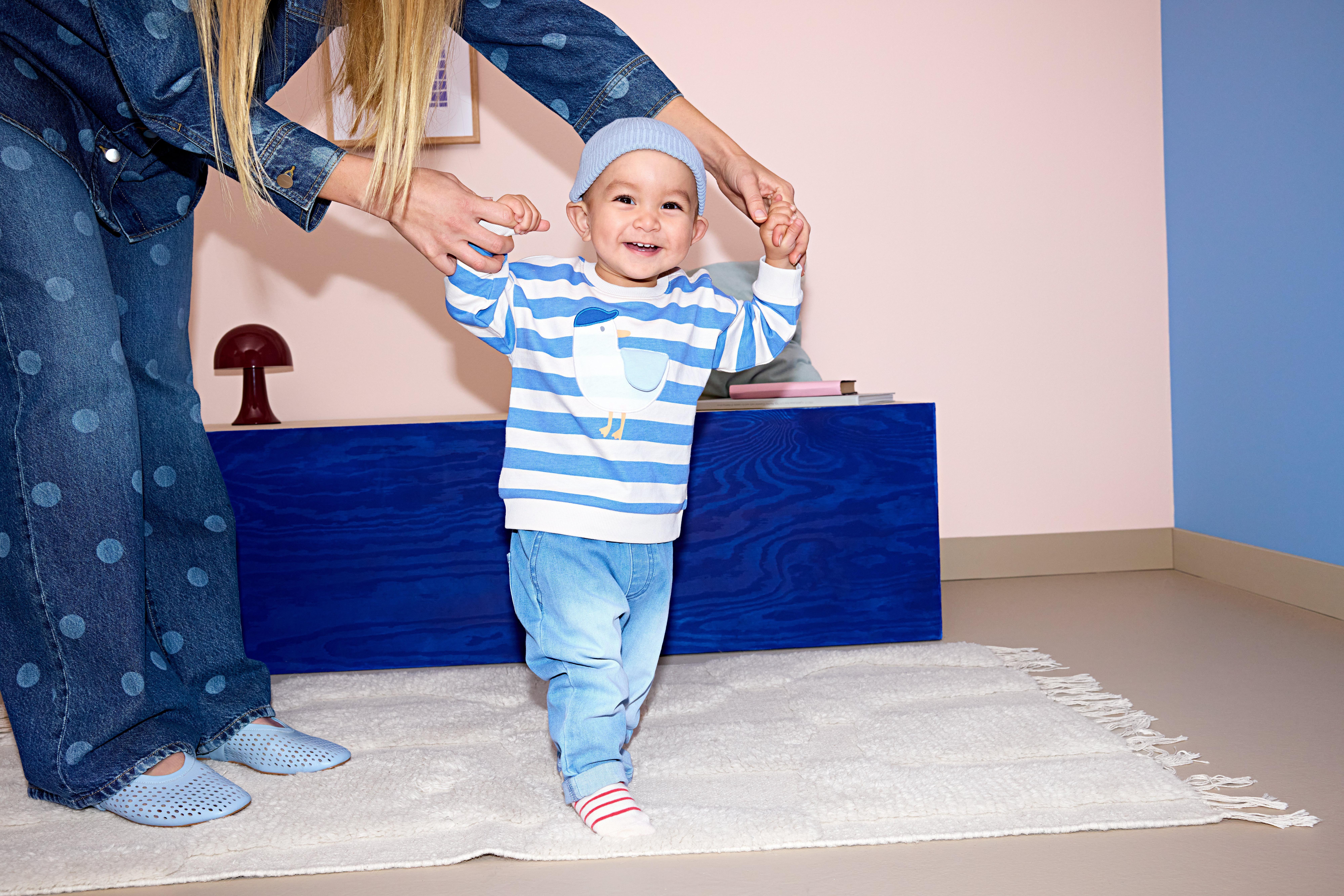 Baby in jeans and blue sweatshirt