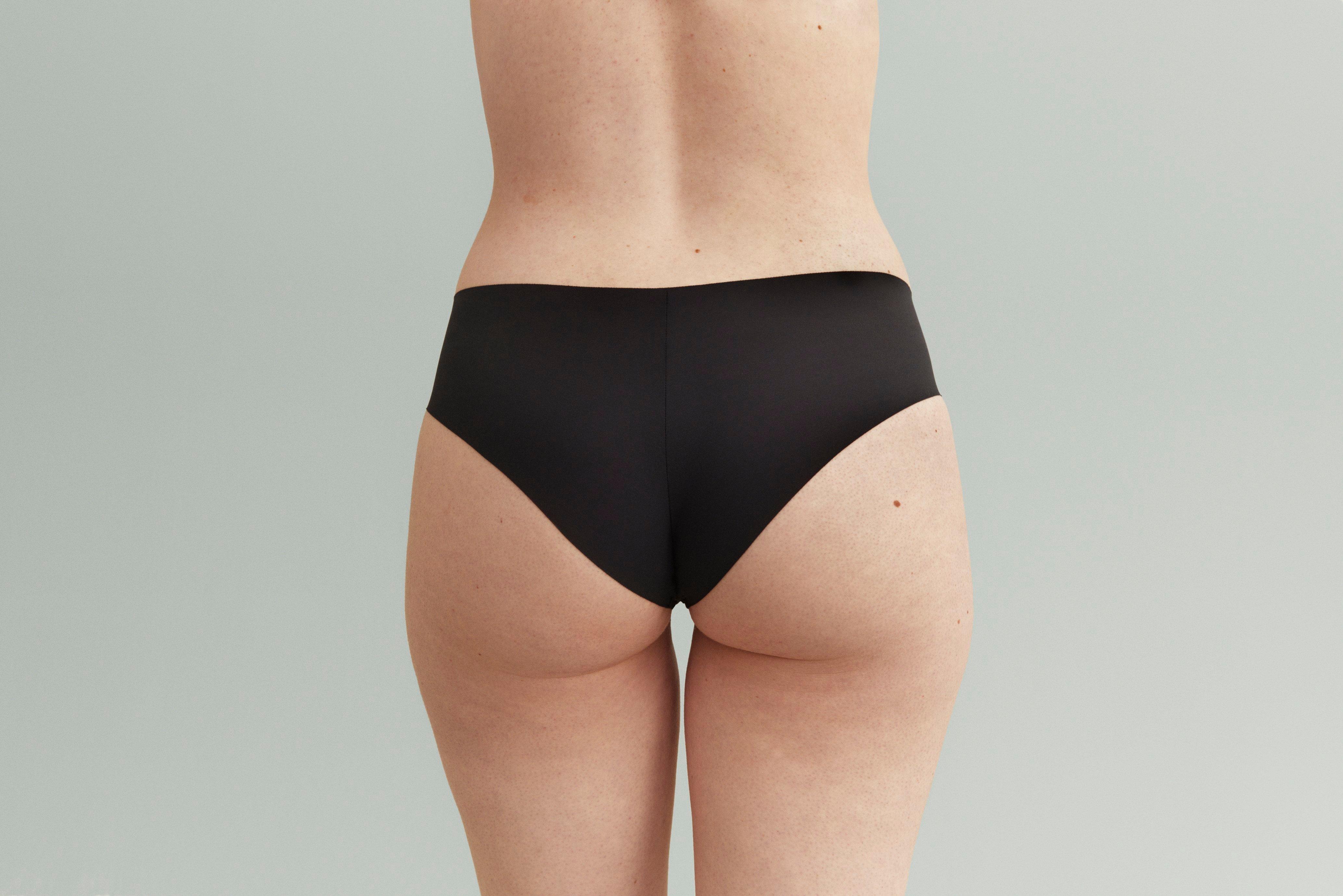 A woman in black brazilian knickers.