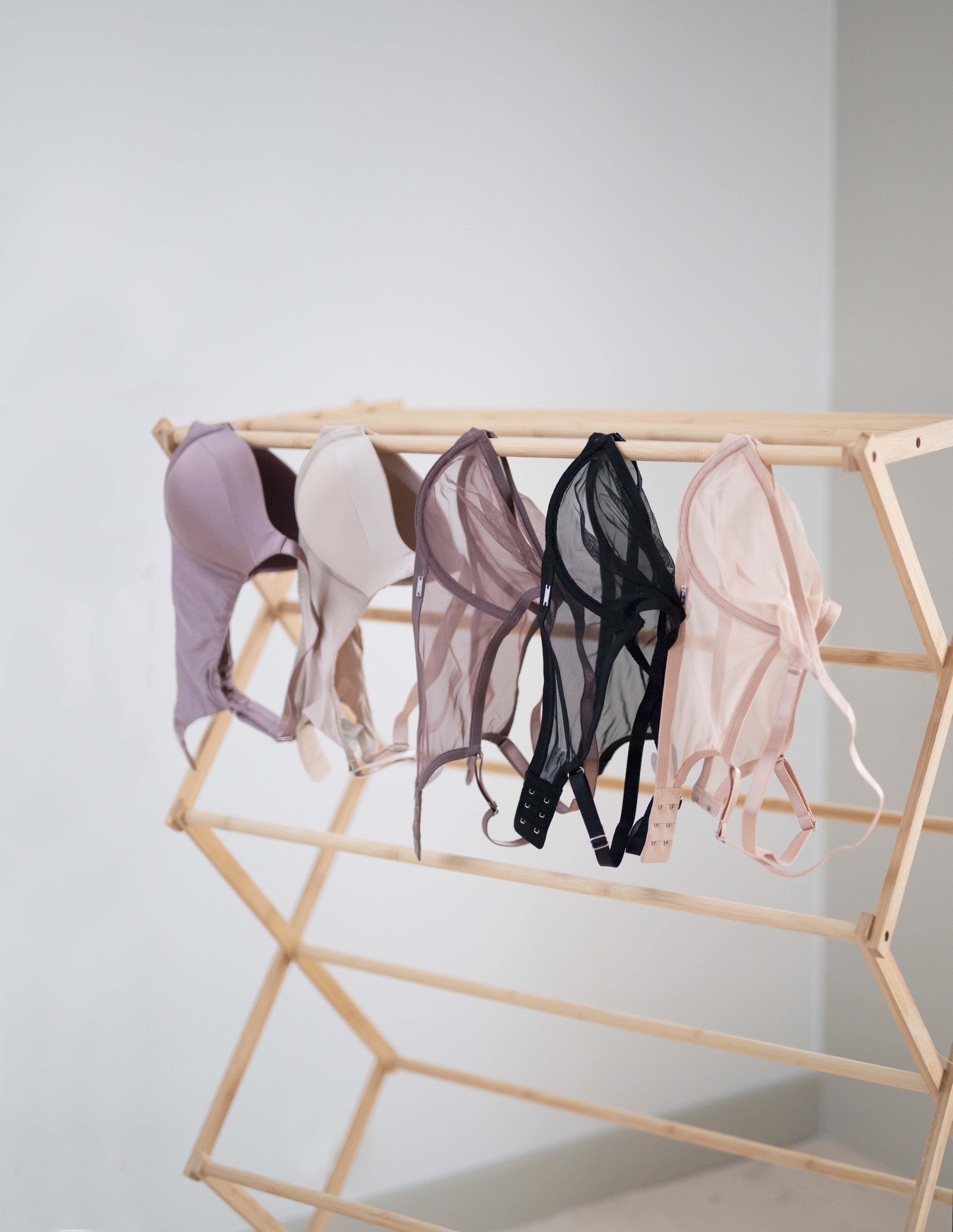 Flera bh:ar som hänger på en torkställning för att torka.