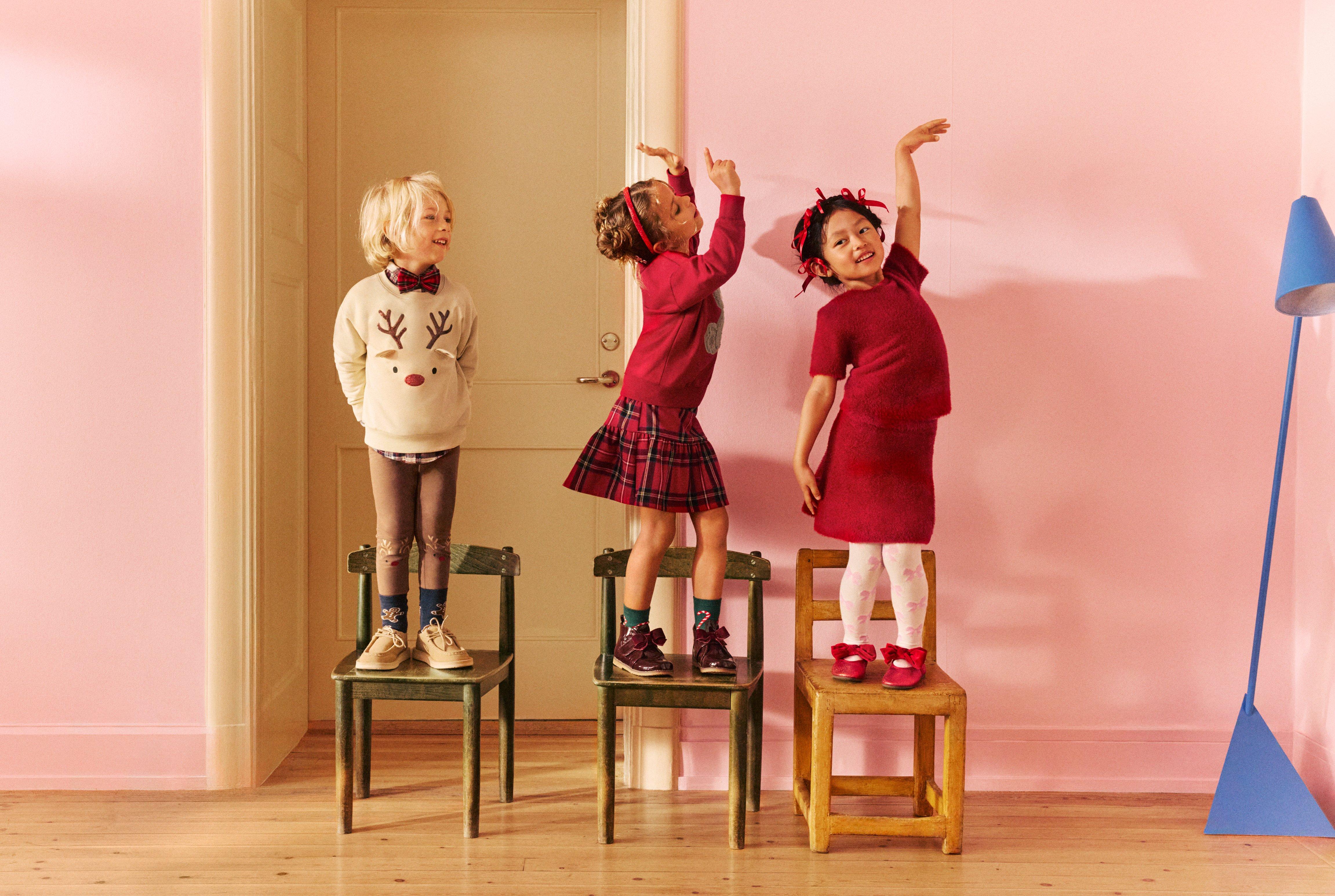 Three children dressed in christmas clothes.