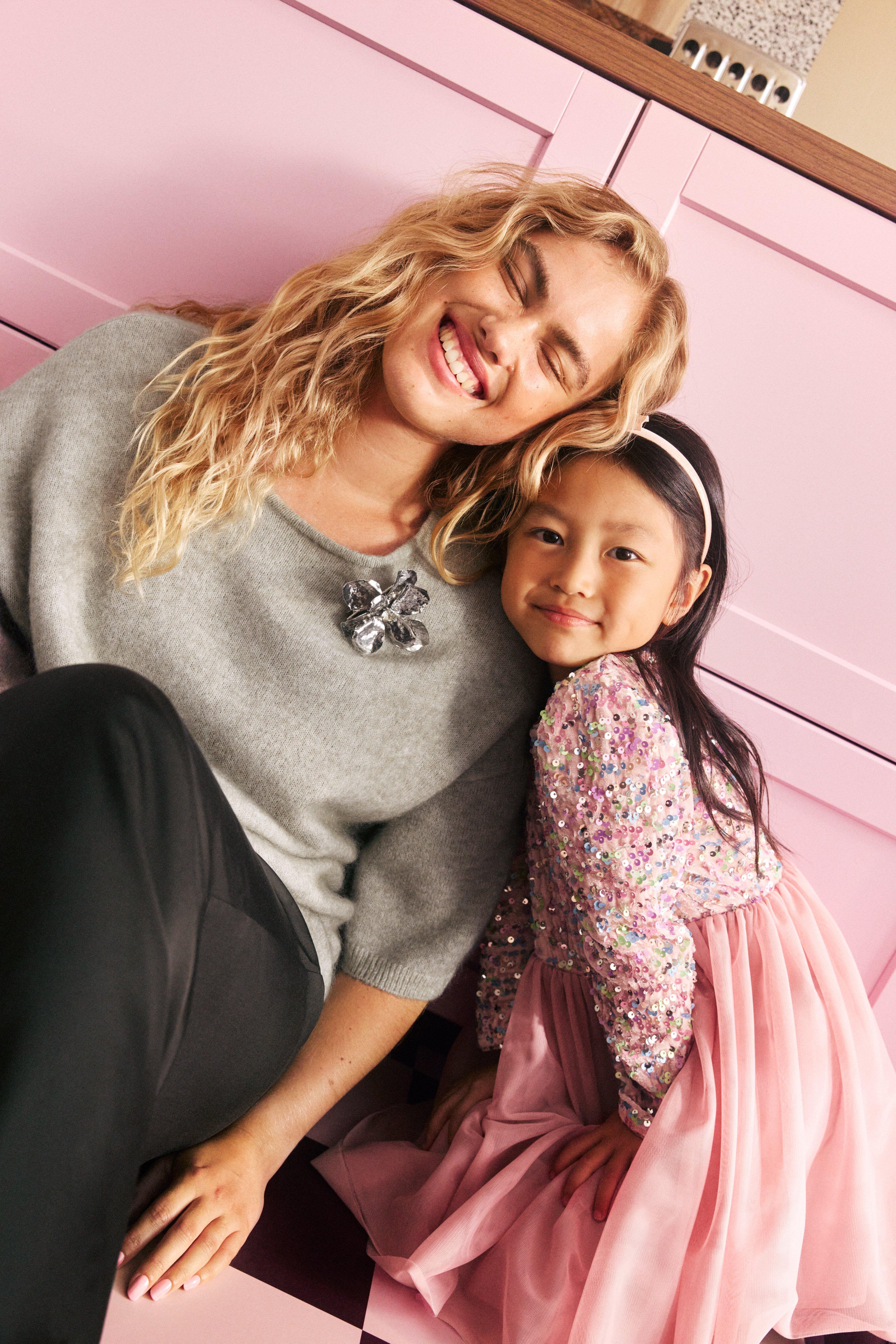 Woman in christmas clothes with a little girl in sequine dress