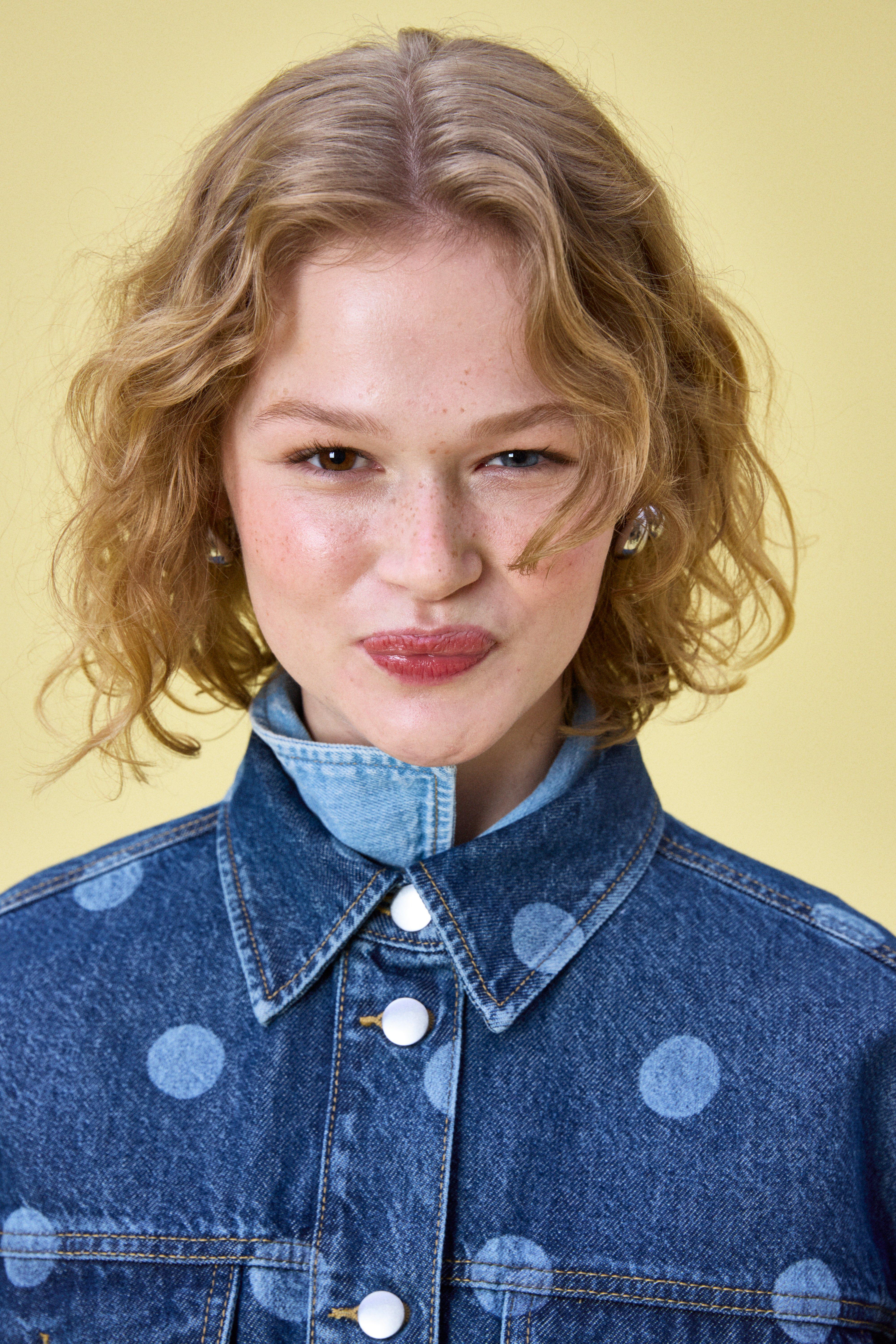 Close-up of a woman in a dark denim shirt with polka dots.