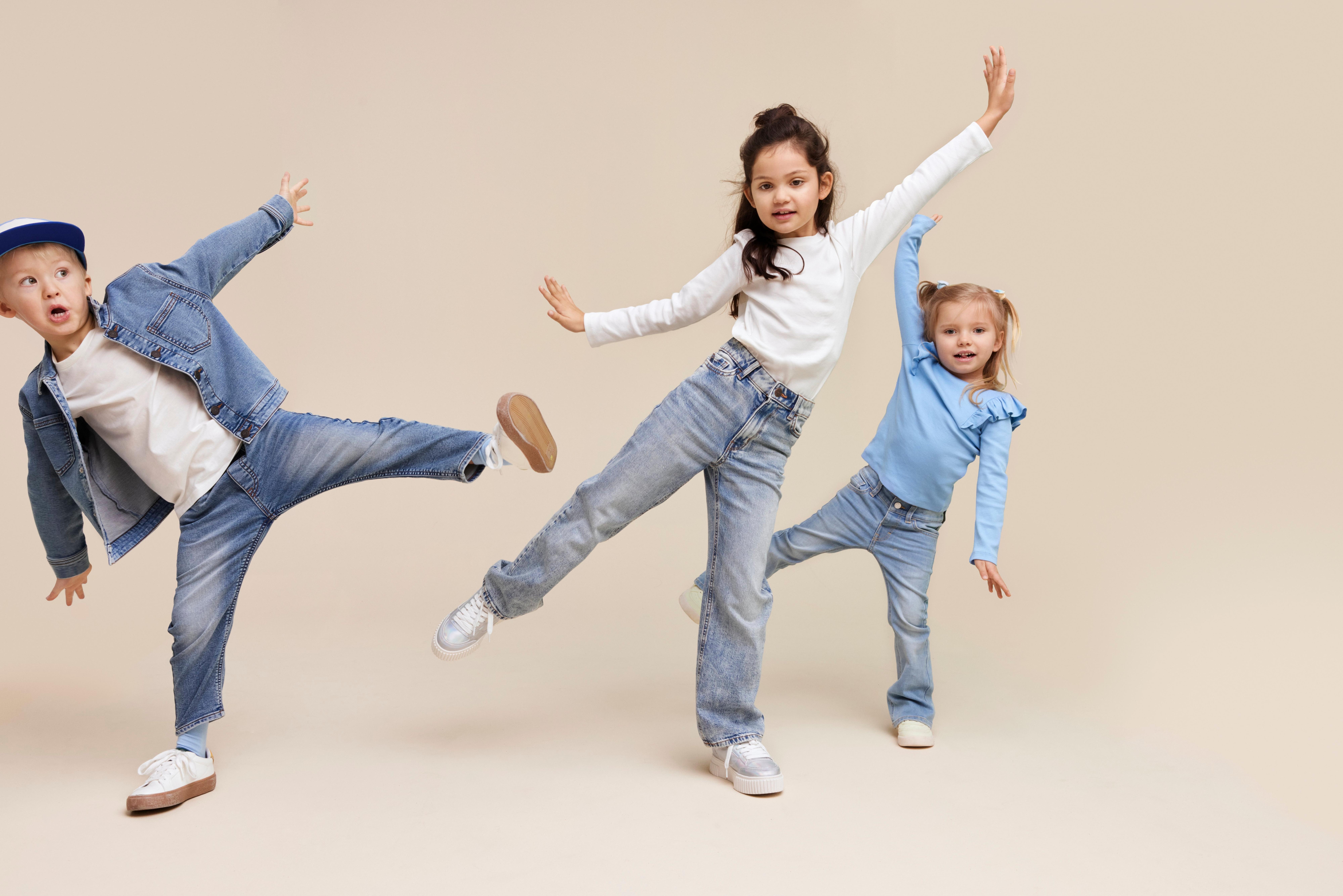 Kolme lasta leikkimässä Lindexin farkuissa.