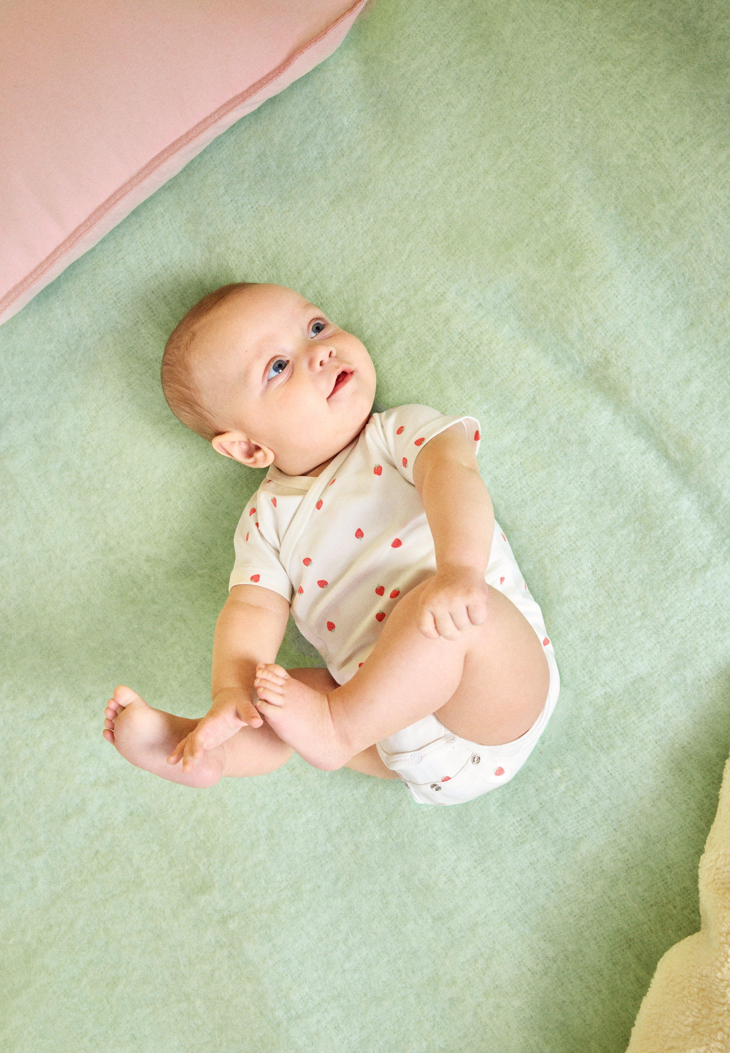Baby wearing a bodysuit from Lindex with buttons in the crotch.