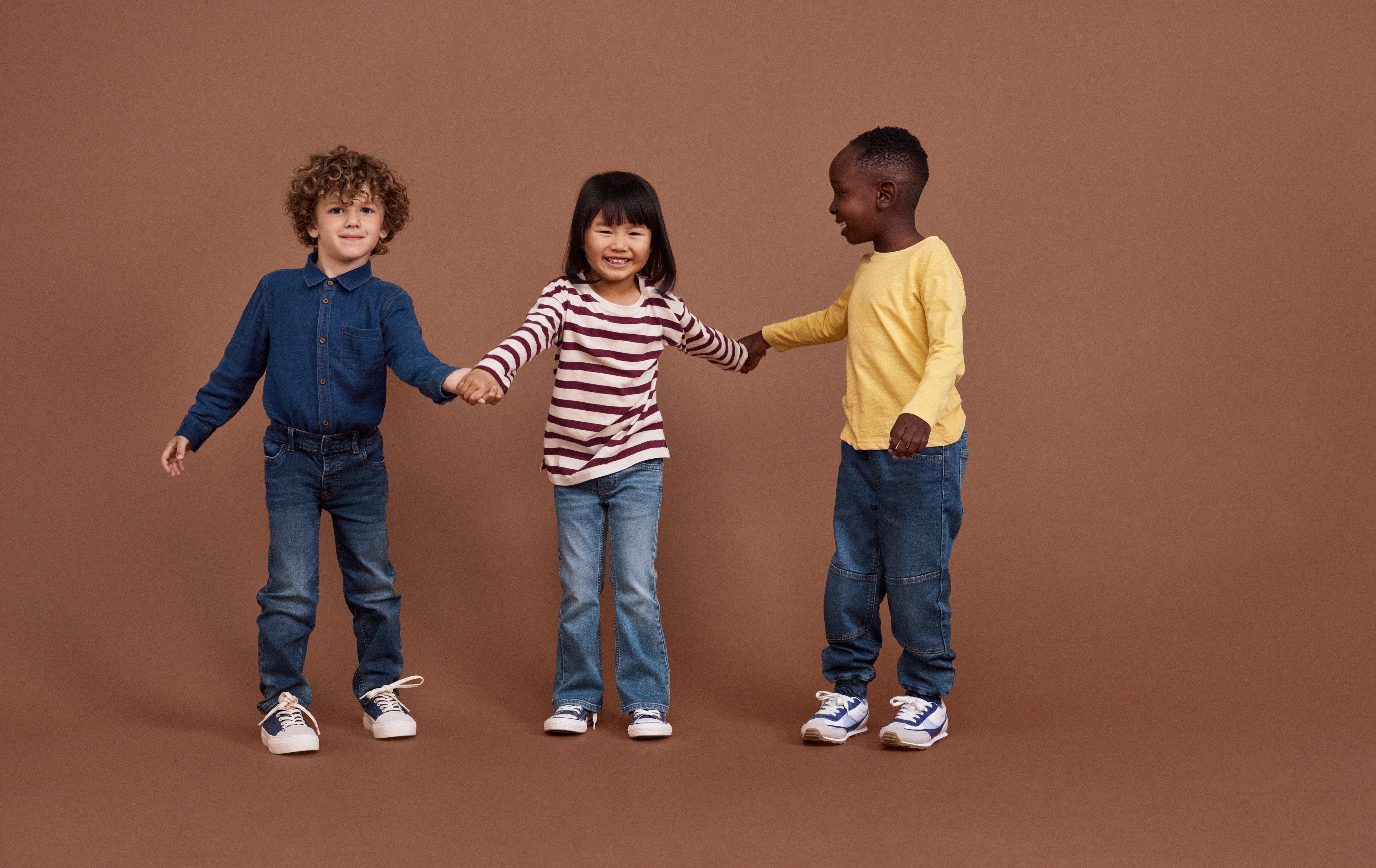 Two children stacking books in a pile.