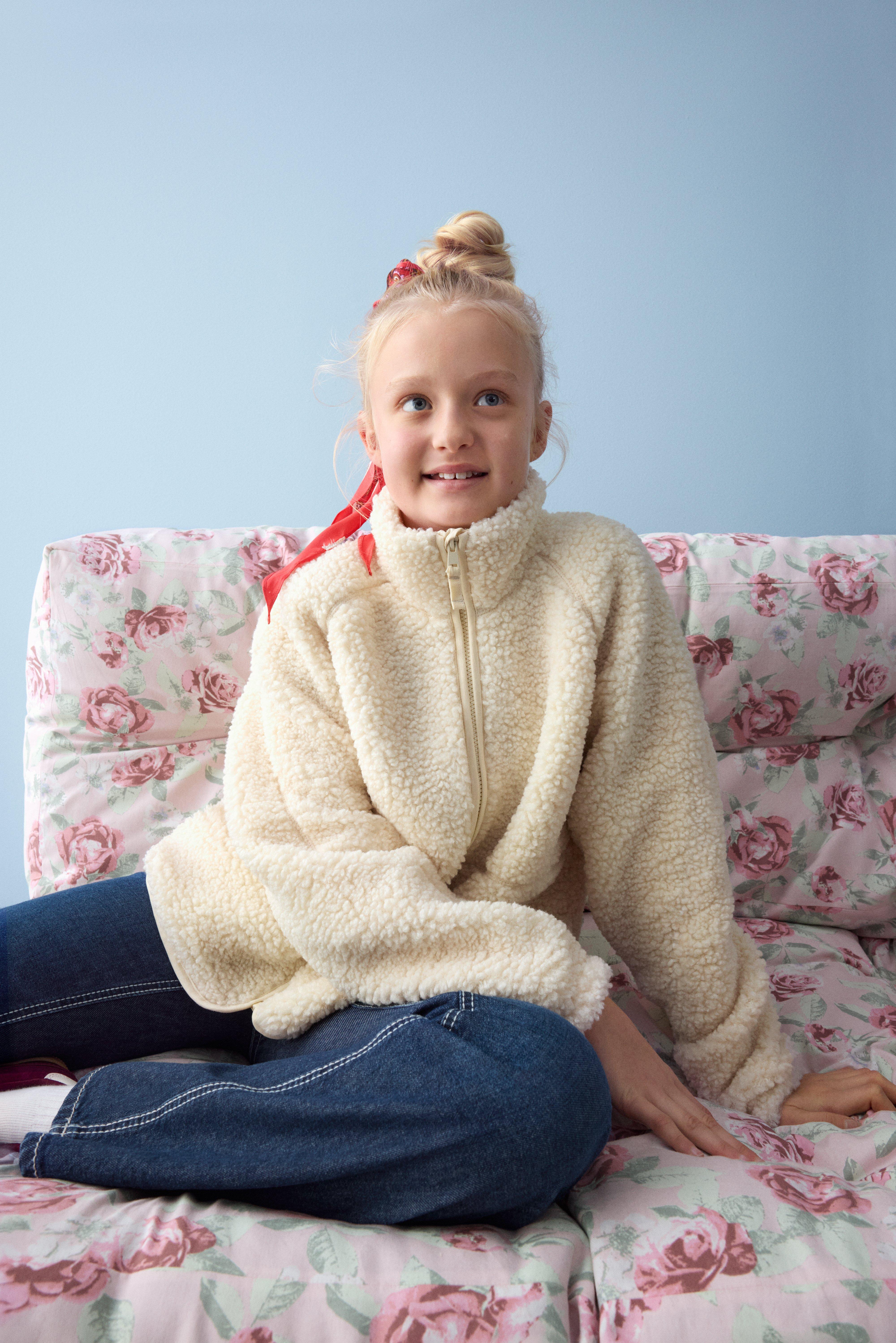 Bild på Harlow, klädd i en vit fleecejacka och ett par jeans.