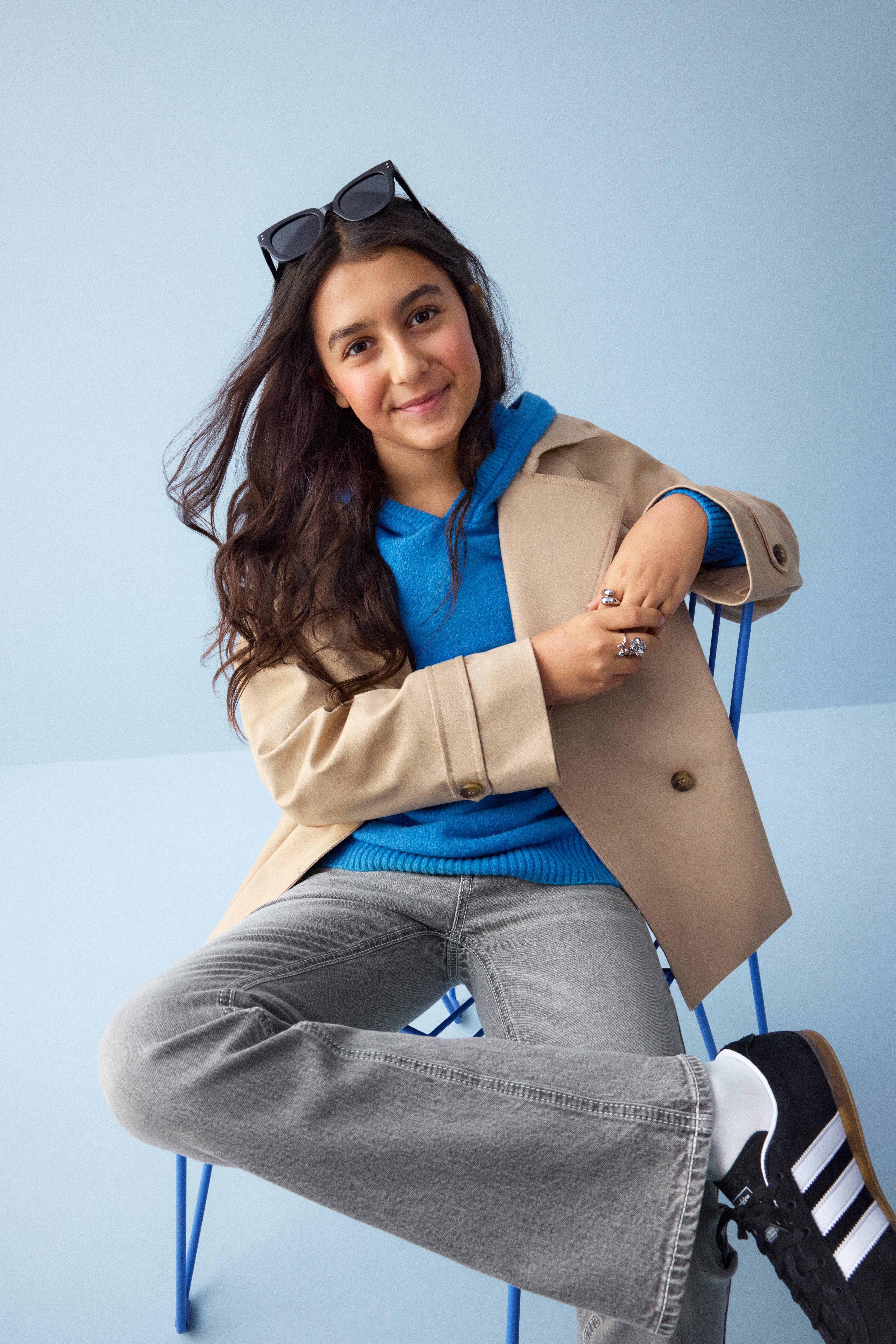 Dítě v lindex oblečení sedící na židli