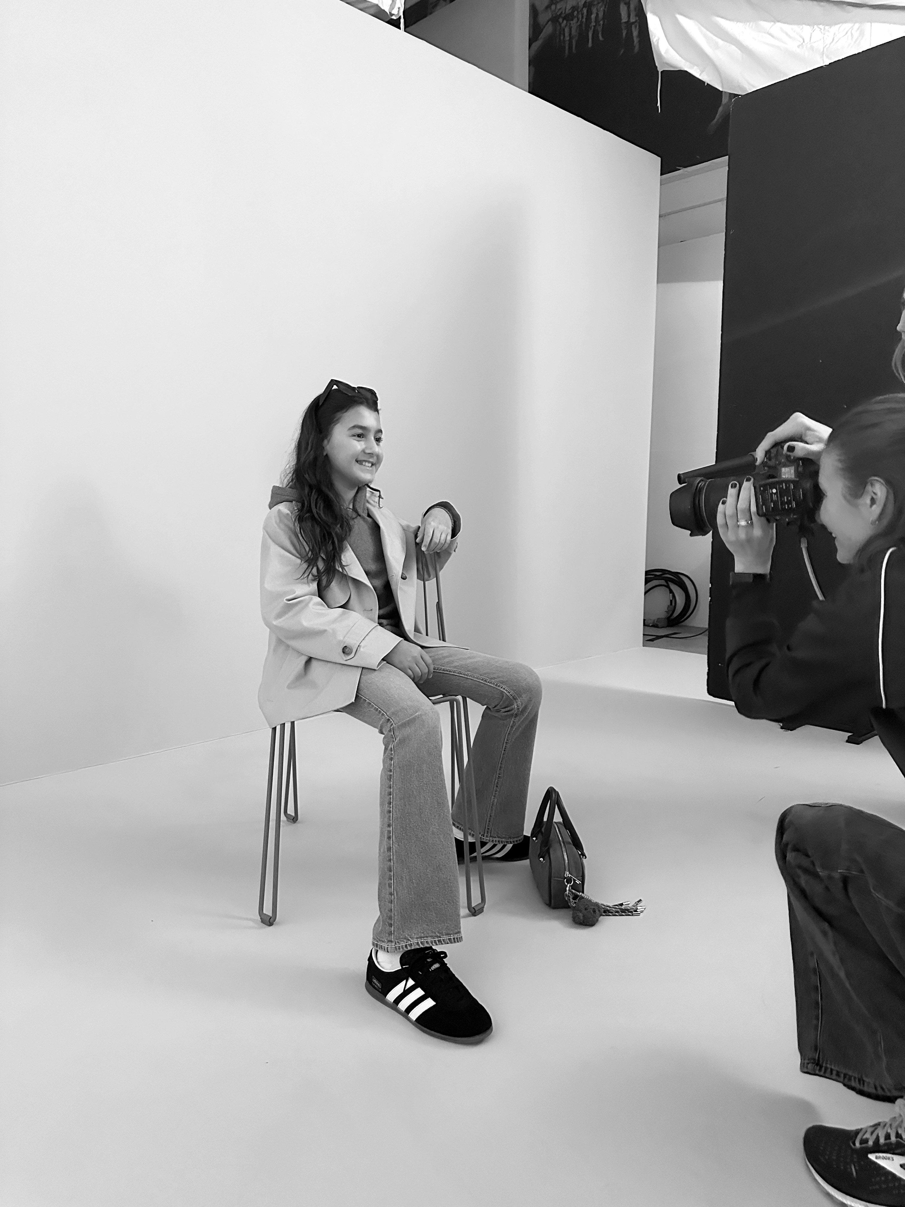 Bild bakom kulisserna från fotosessionen med Malcolm. Här sitter Malcolm på en stol och en fotograf tar en bild.