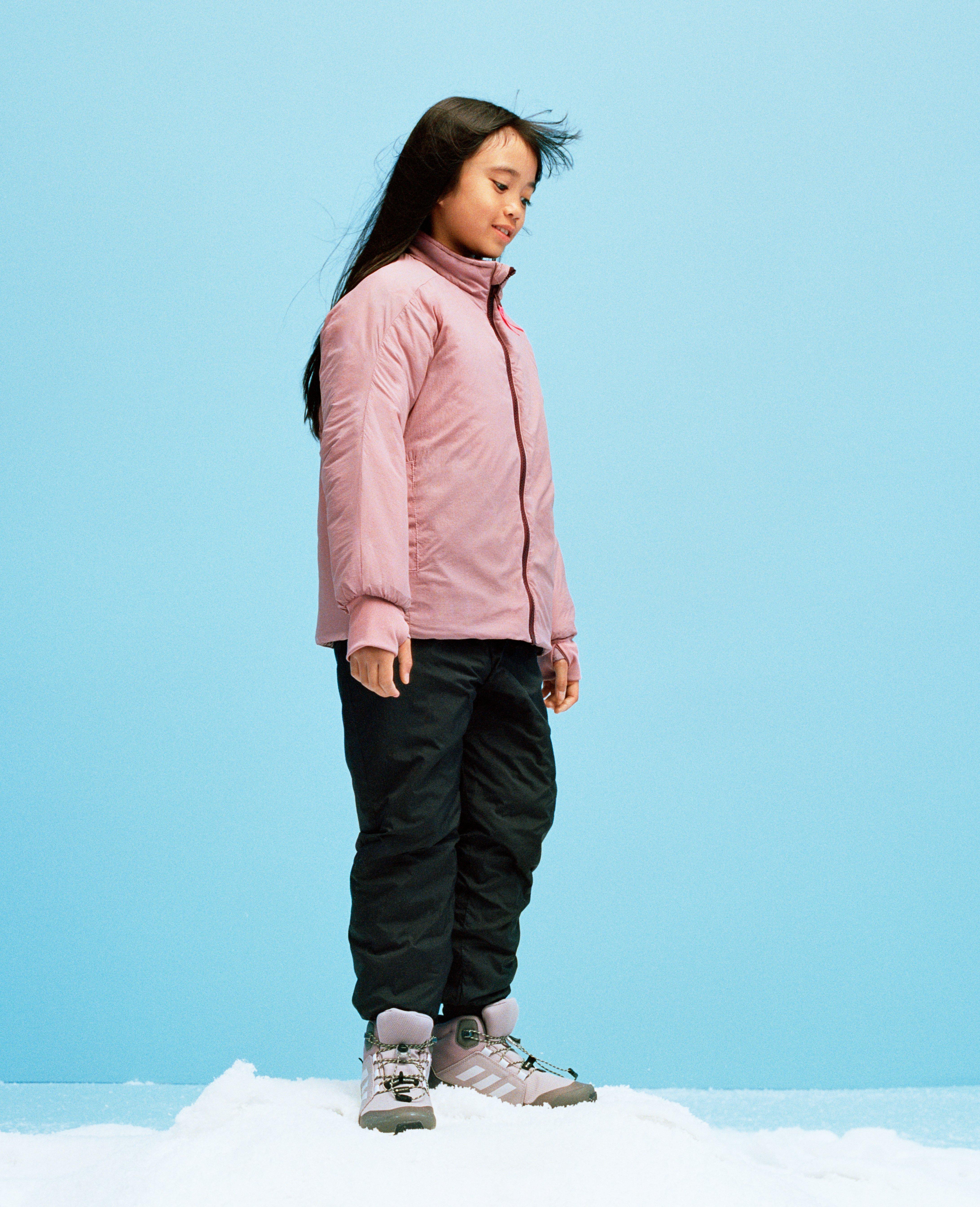 En flicka klädd i en rosa vadderad lättviktsjacka