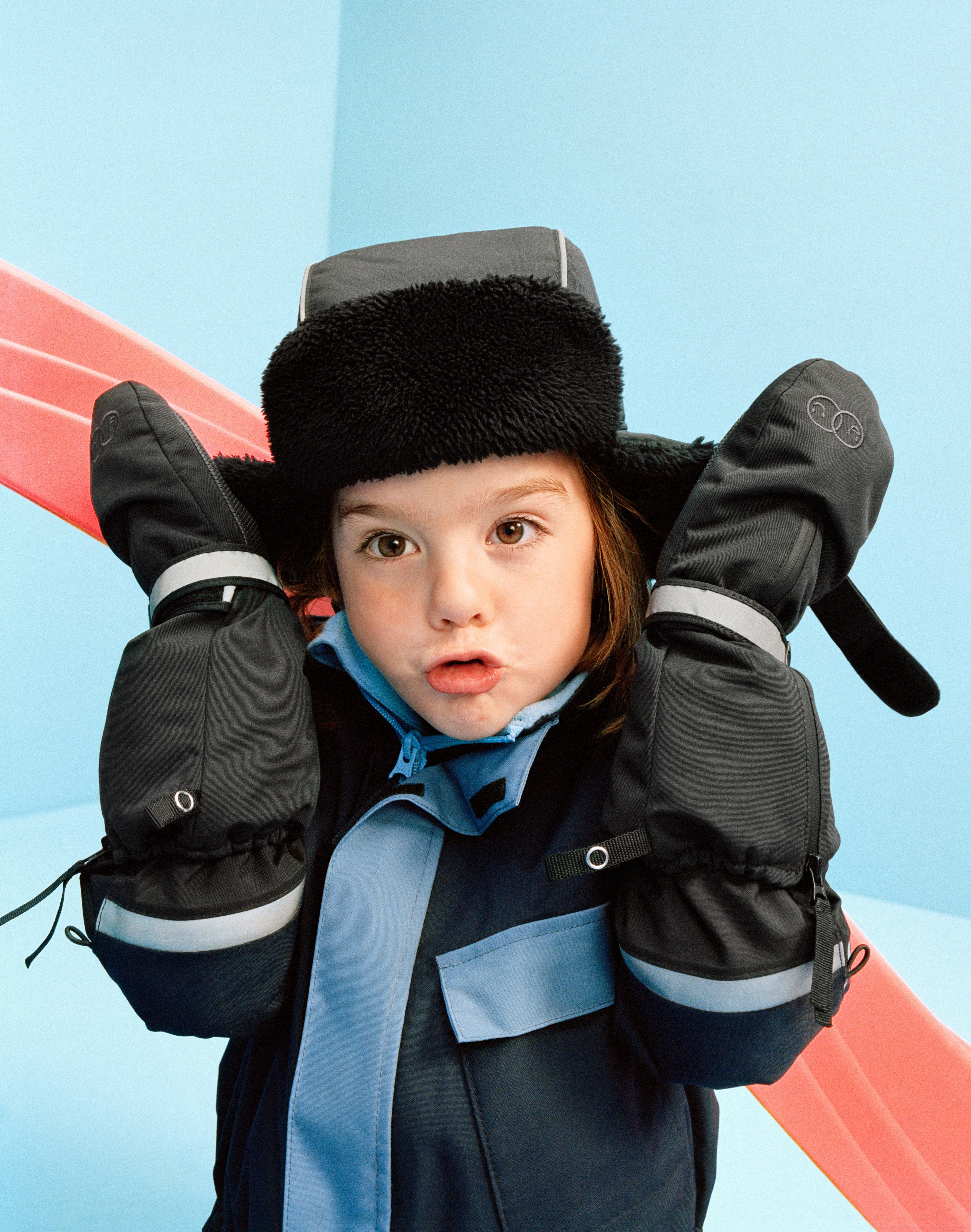 Child playing wearing warm and comfortable mittens and a warm hat from Lindex.