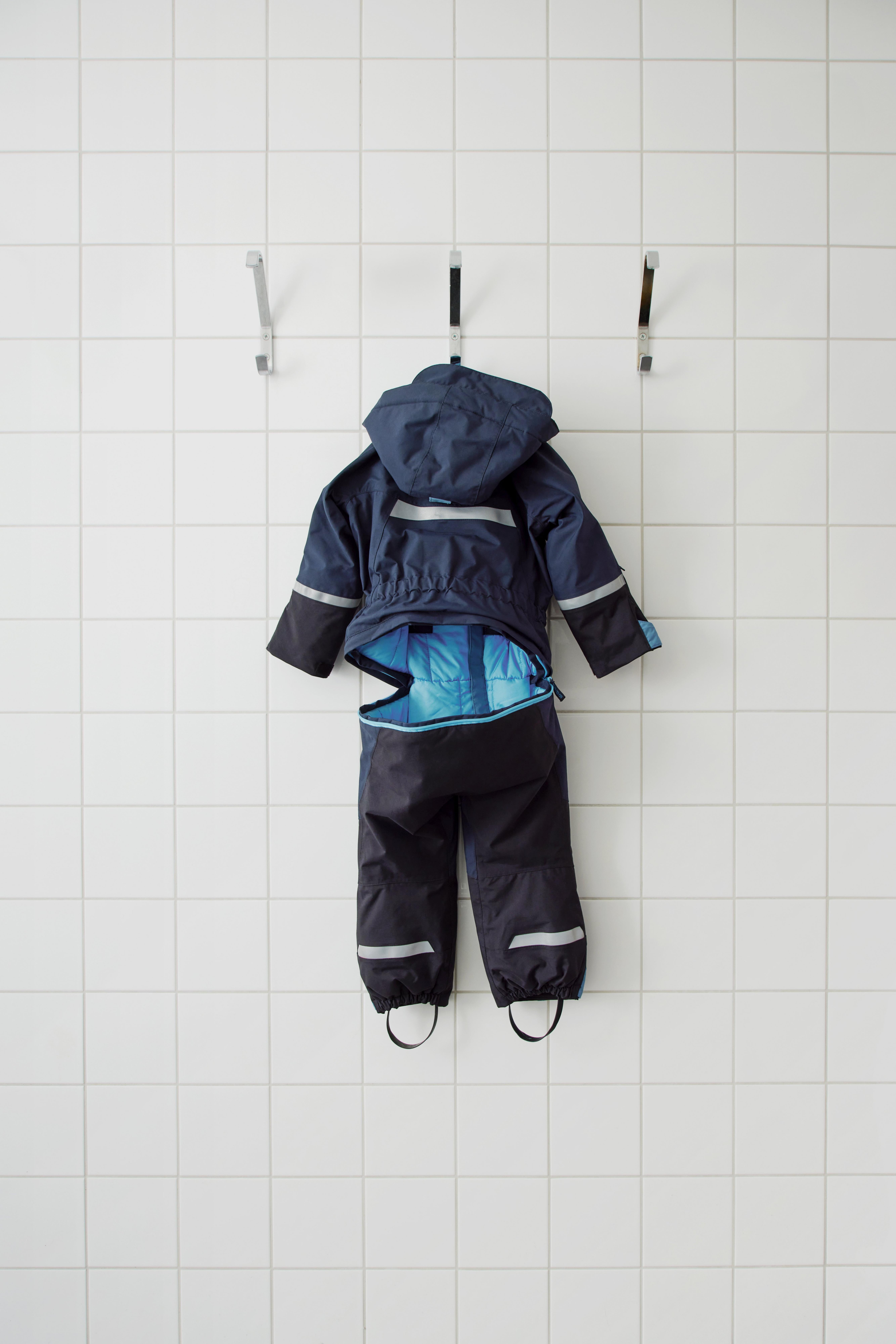 A snow suit hanging to dry with the drop seat open.