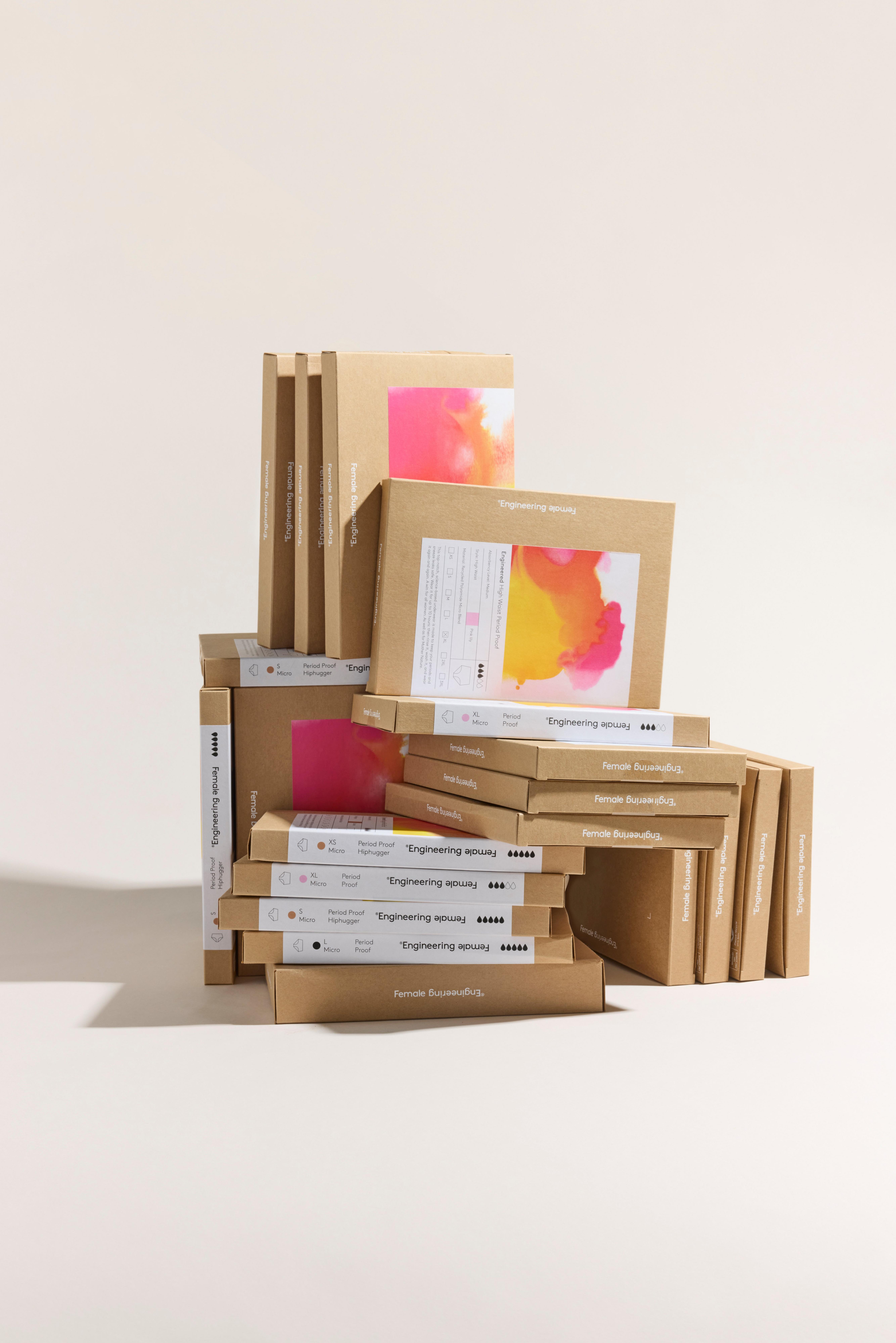 Kvinnliga ingenjörsprodukter i en hög.