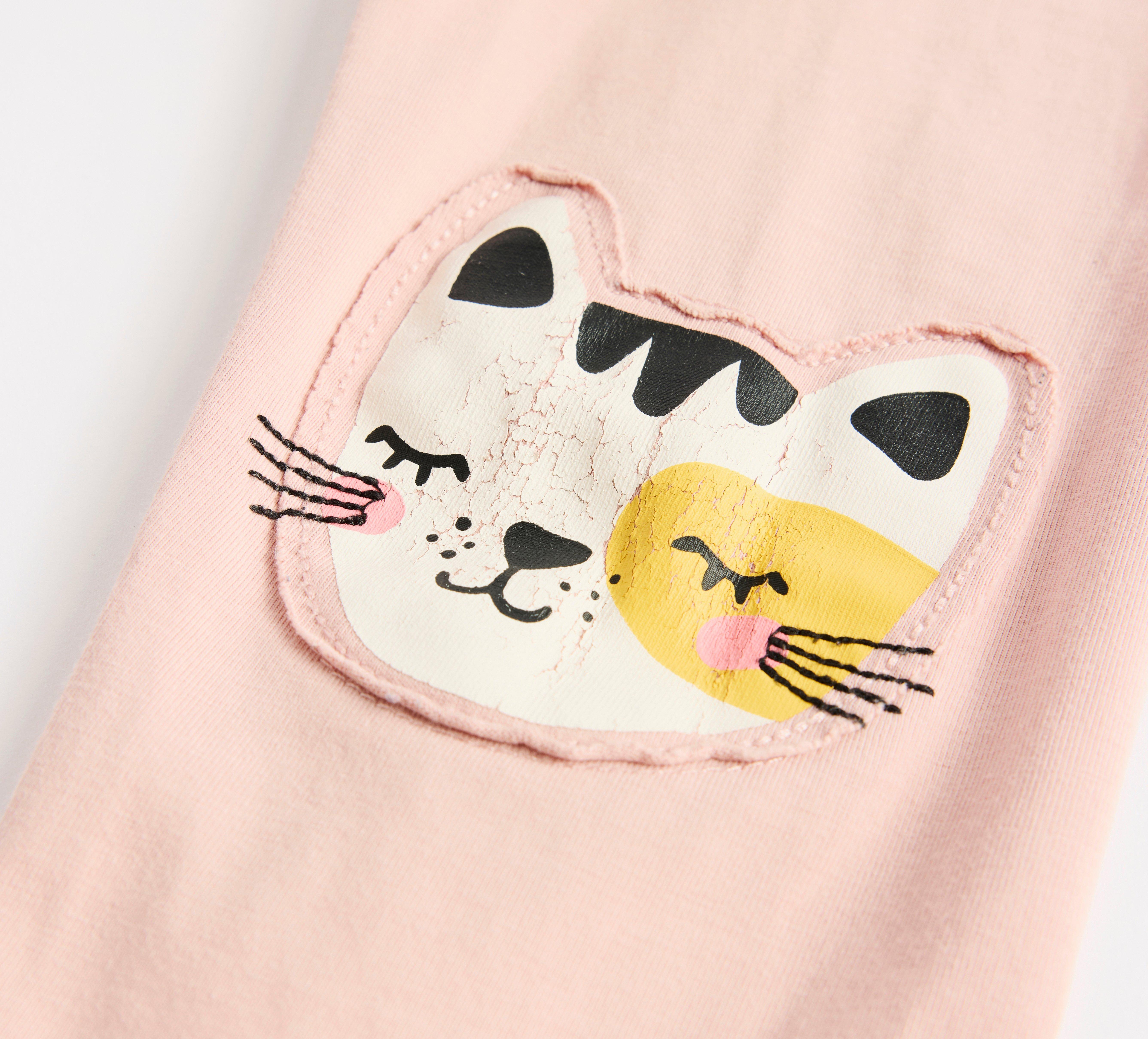  Ett par barnbyxor med katttryck på knät.