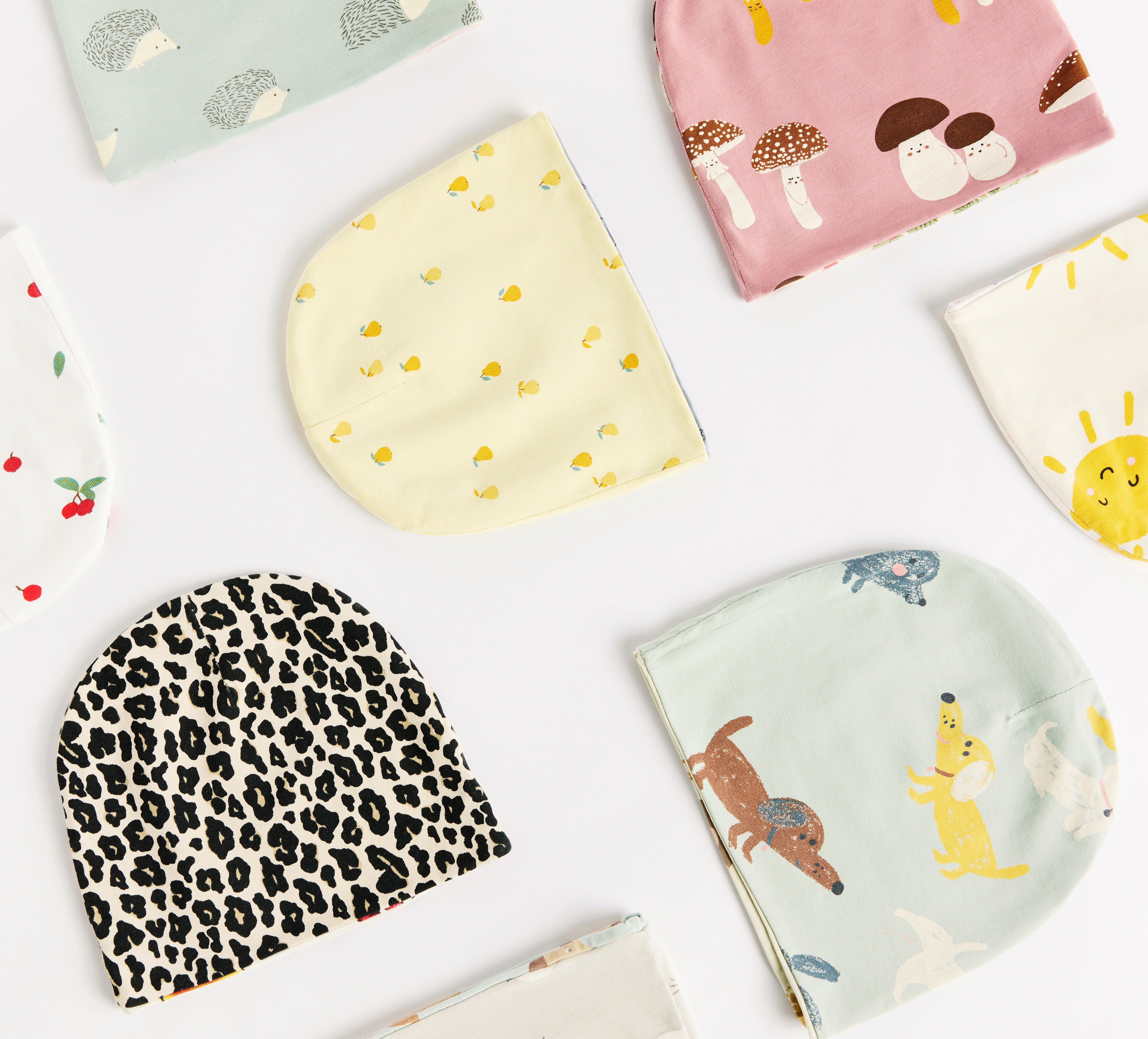 En bild på flera babymössor i olika mönster som visar att ingen mössa är den andra lik.