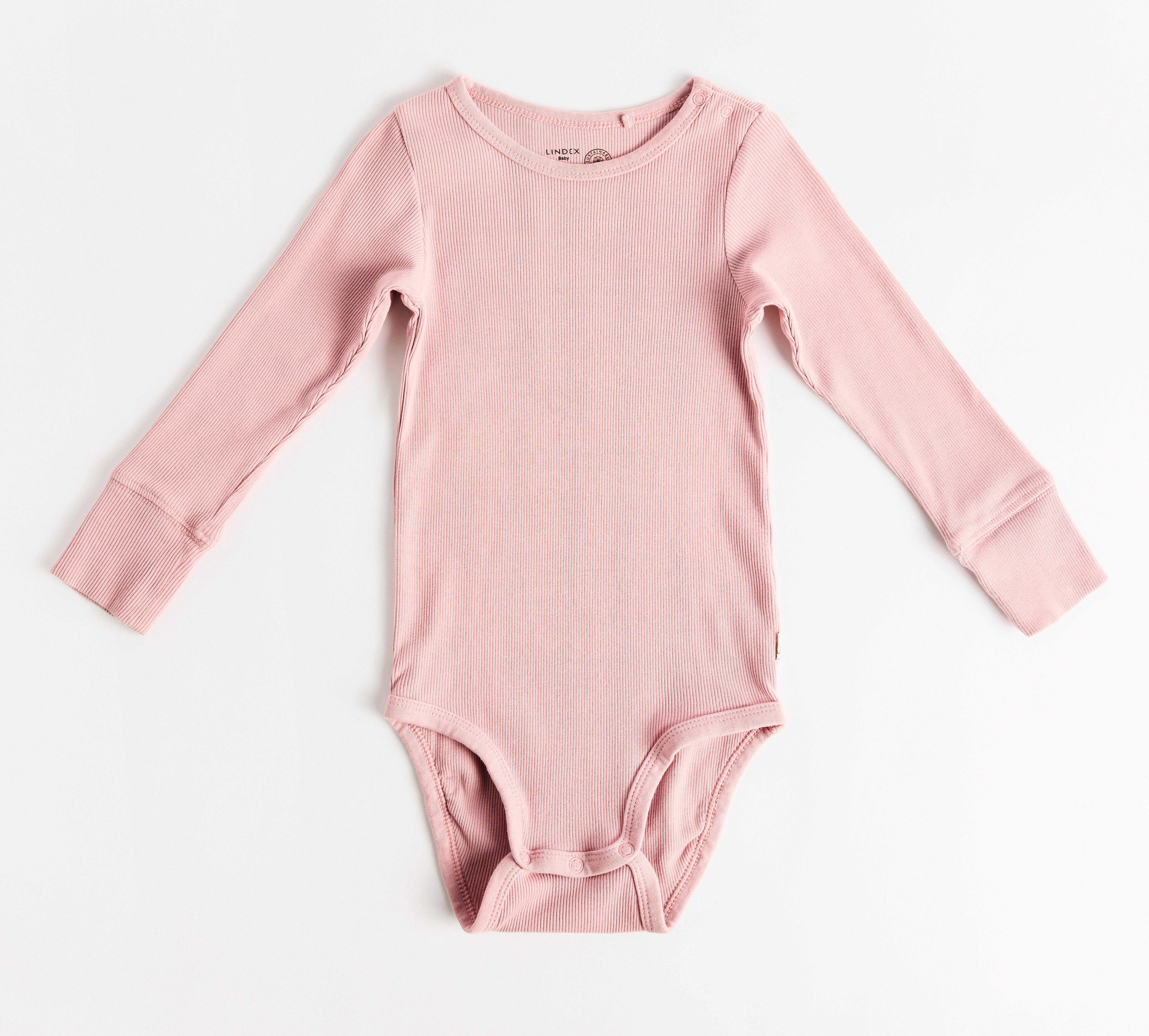 En rosa baby body mot en ljus bakgrund.