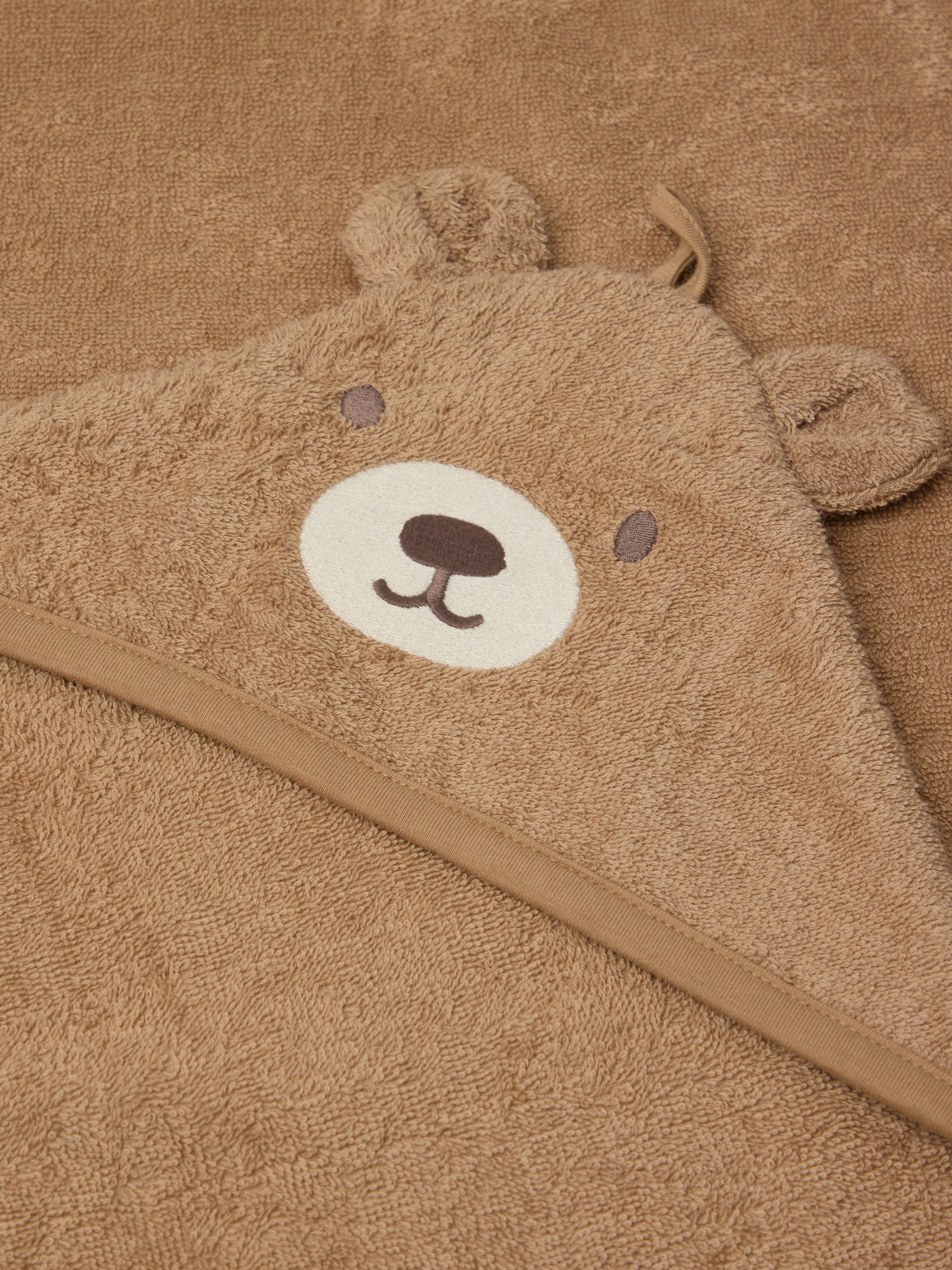 A brown blanket with a bear face and ears.