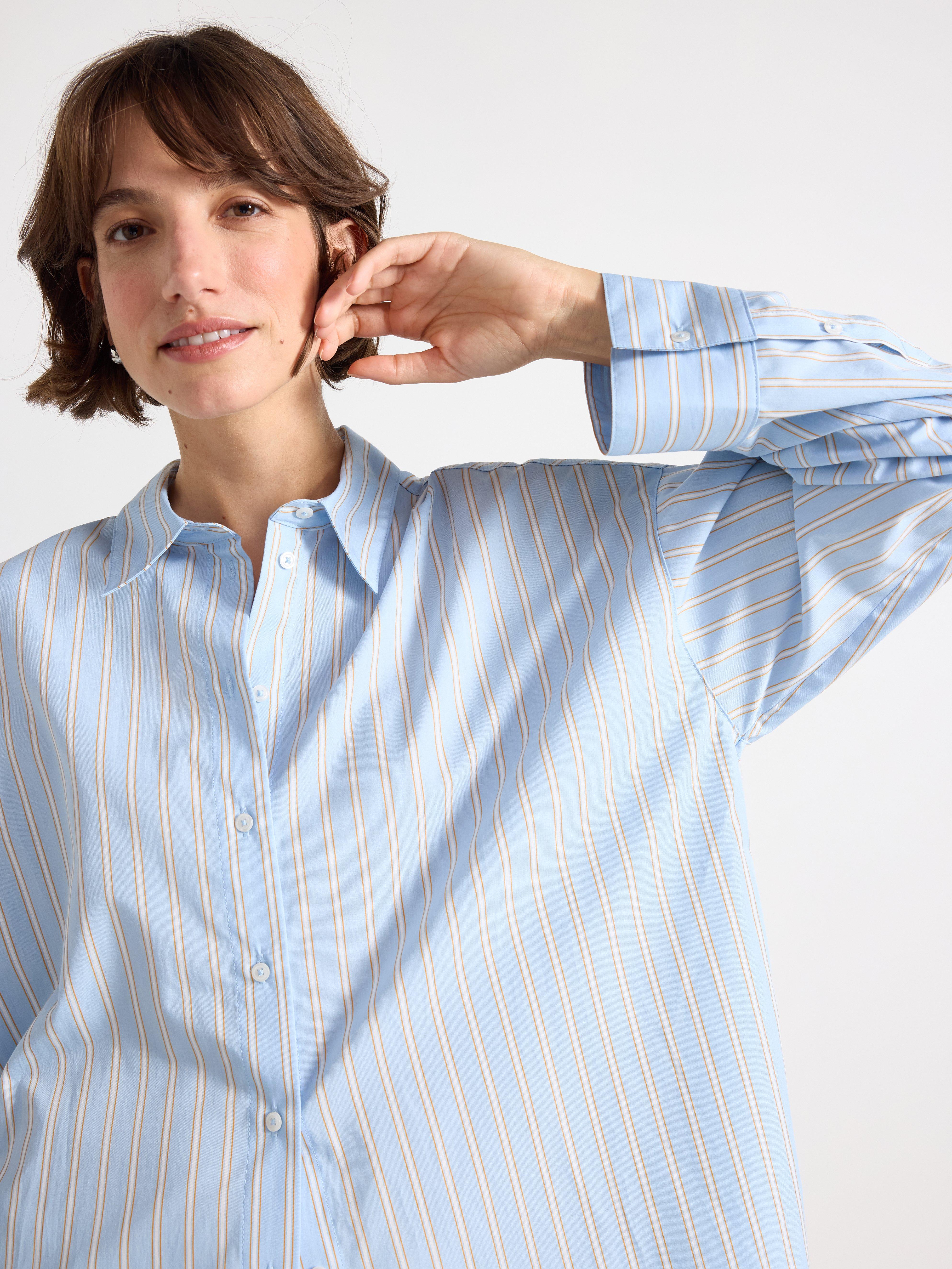 Close-up of a woman wearing a light blue shirt.