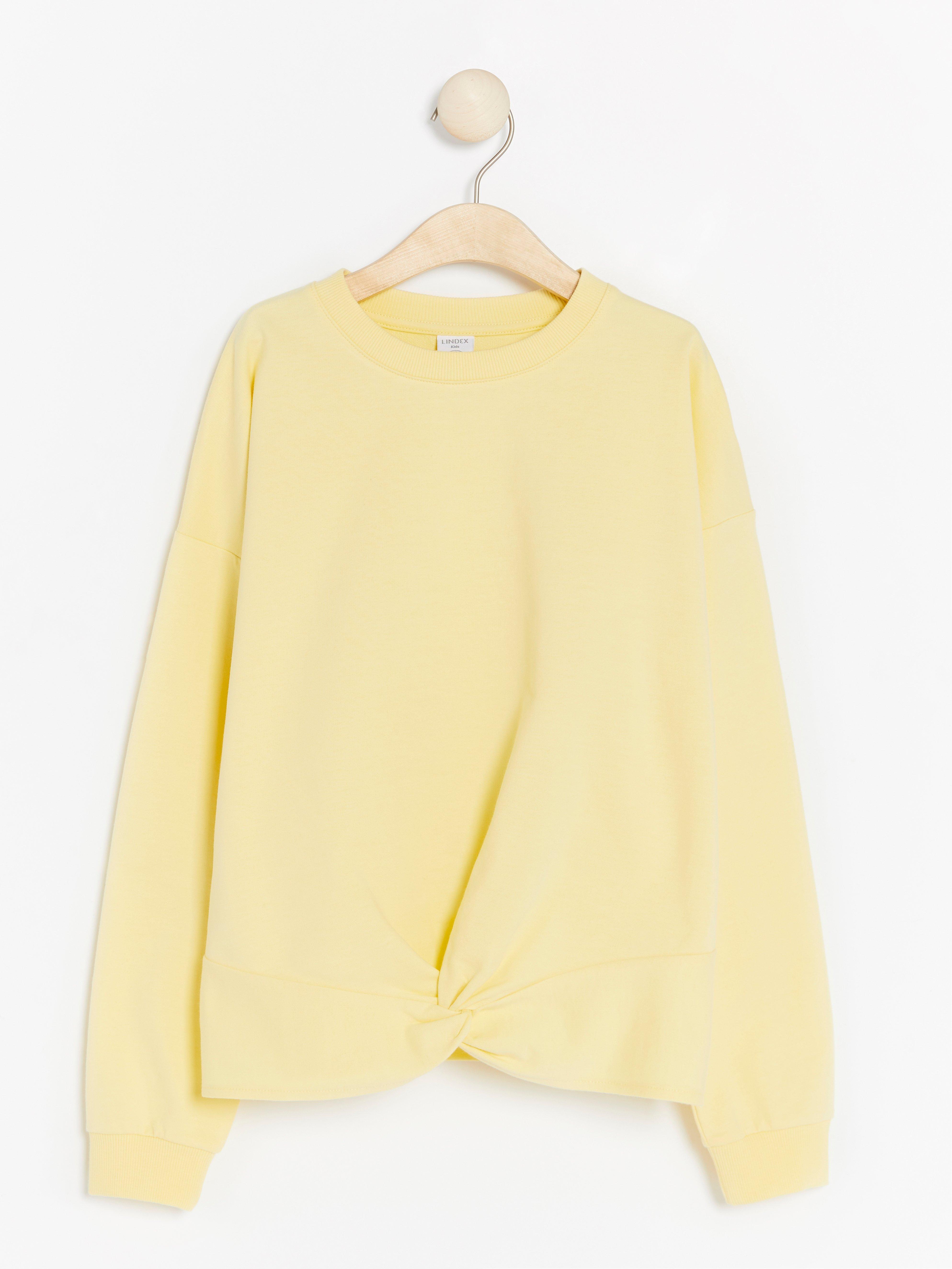 be the light yellow sweatshirt