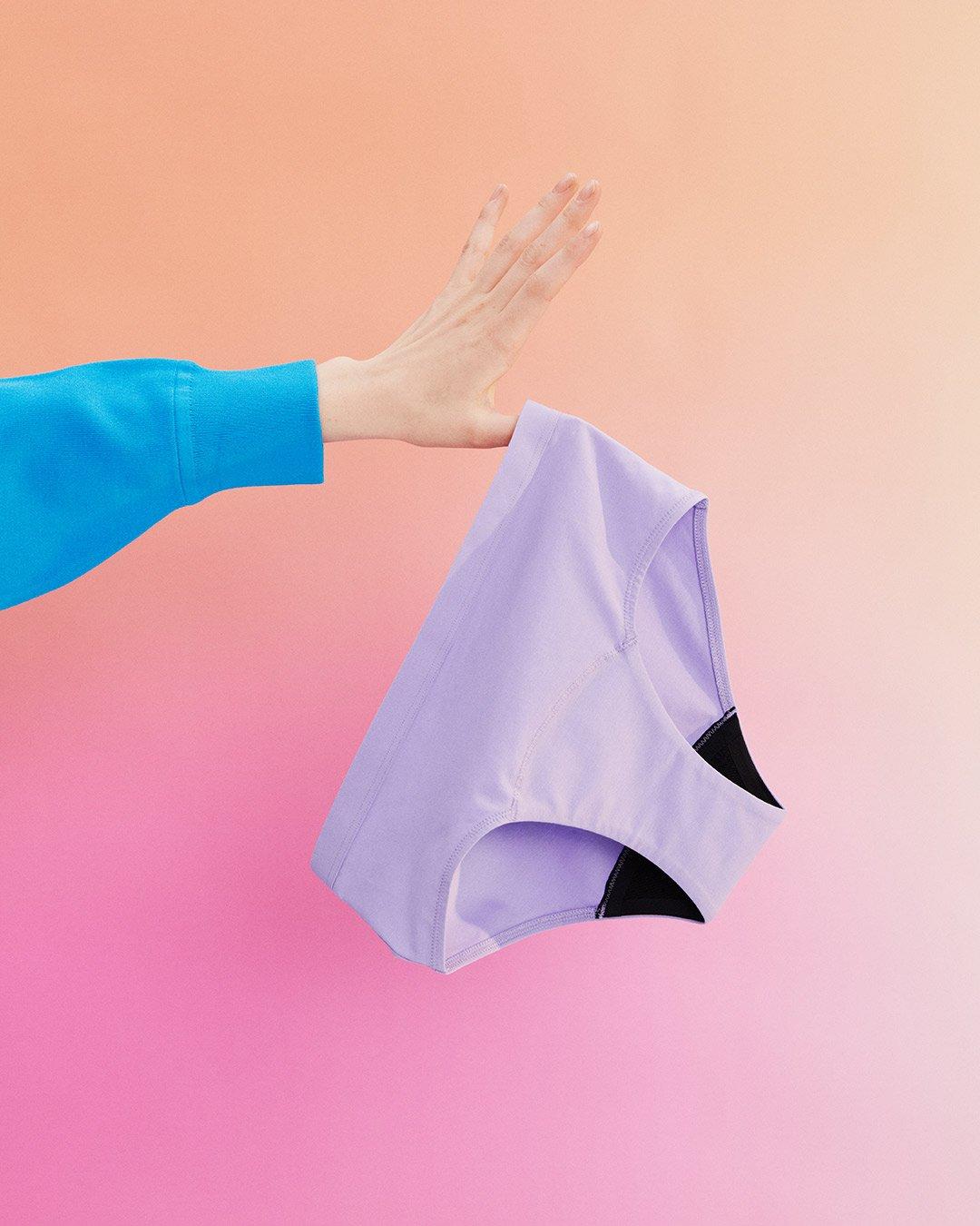 A hand holding a pair of period panties.