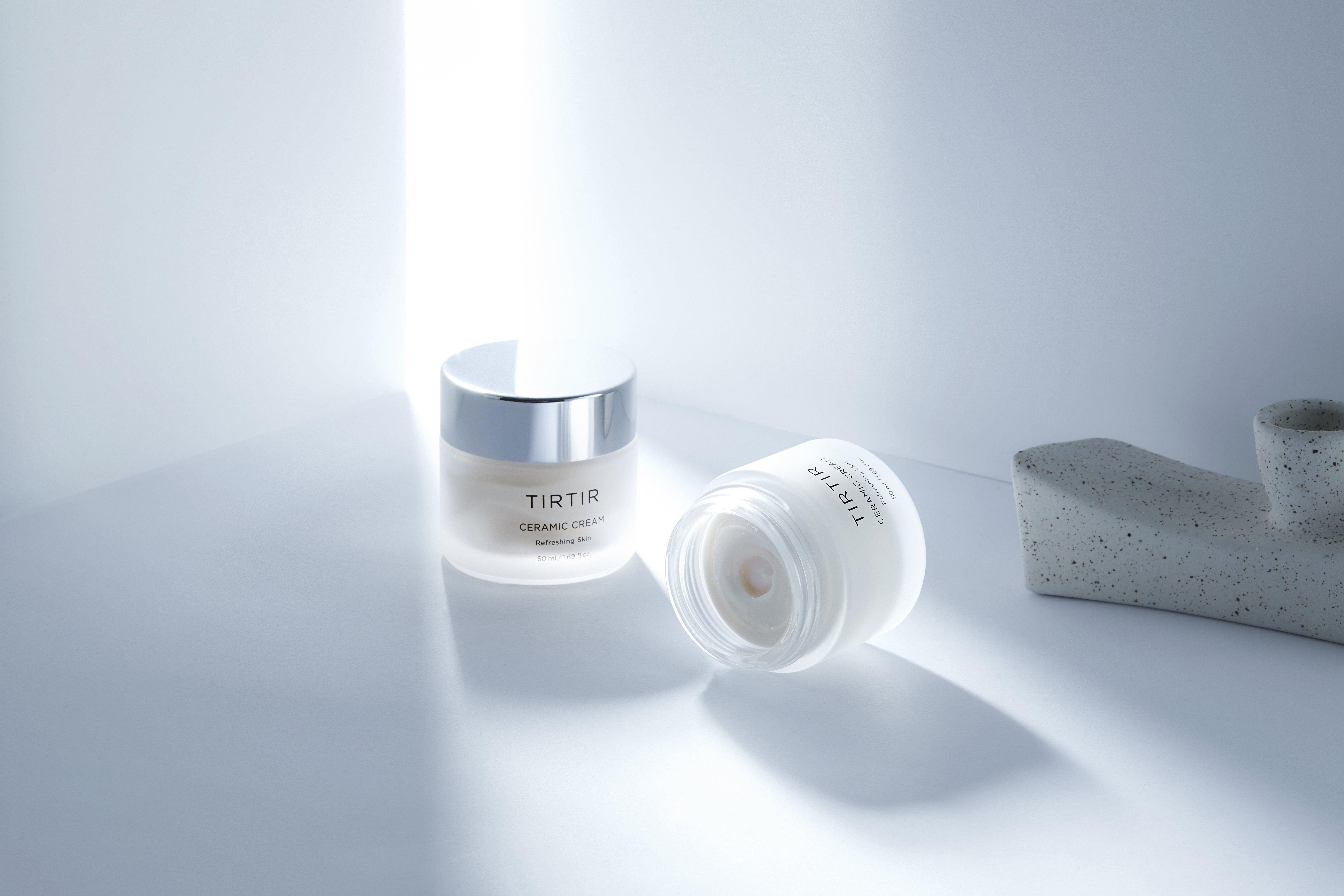 To krukker fra TIRTIR. Den ene står opp, den andre ligger ned og er åpen slik at du kan se kremen i glasset.