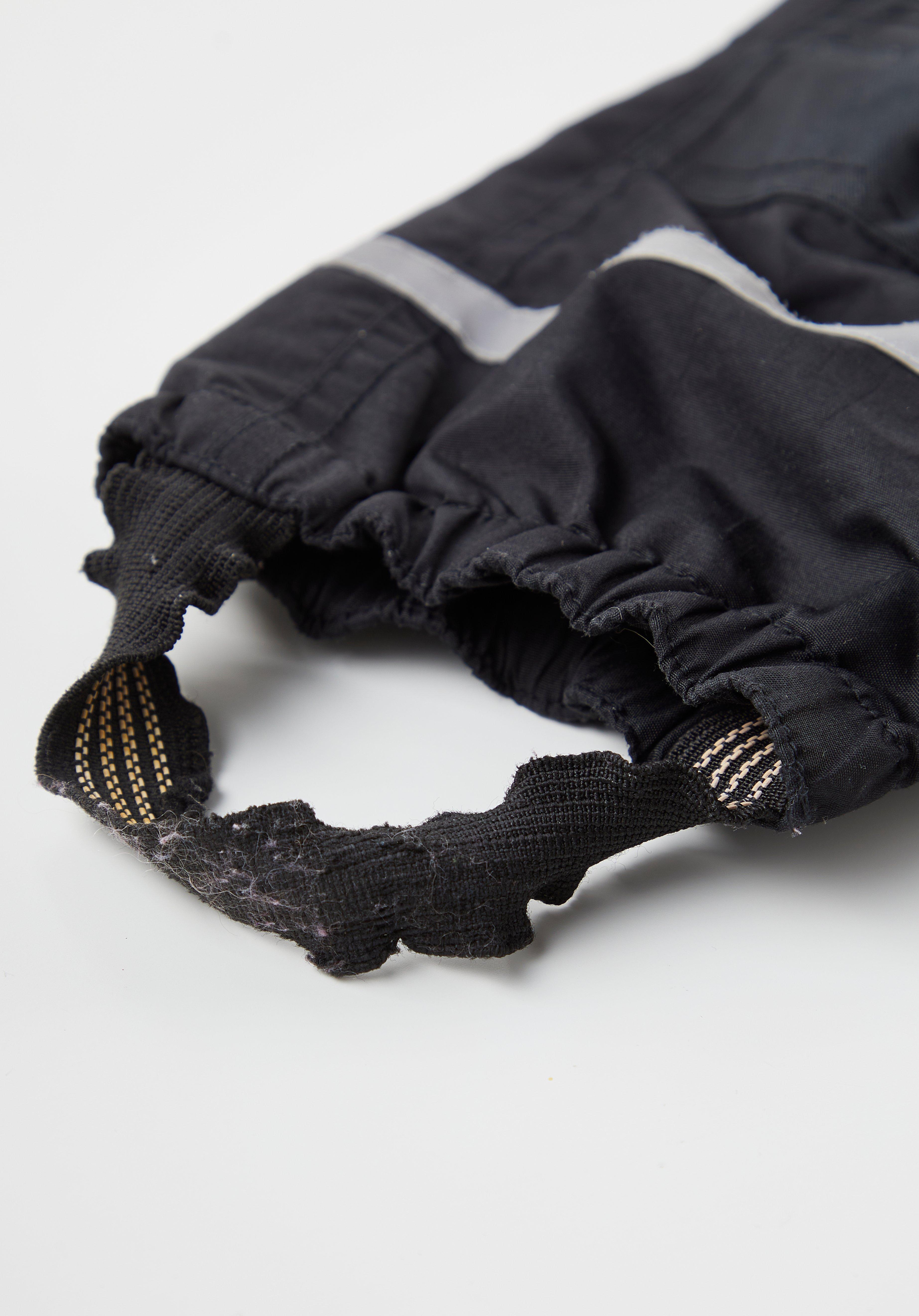 En slitt fotstropp på en kjeledress til et barn.