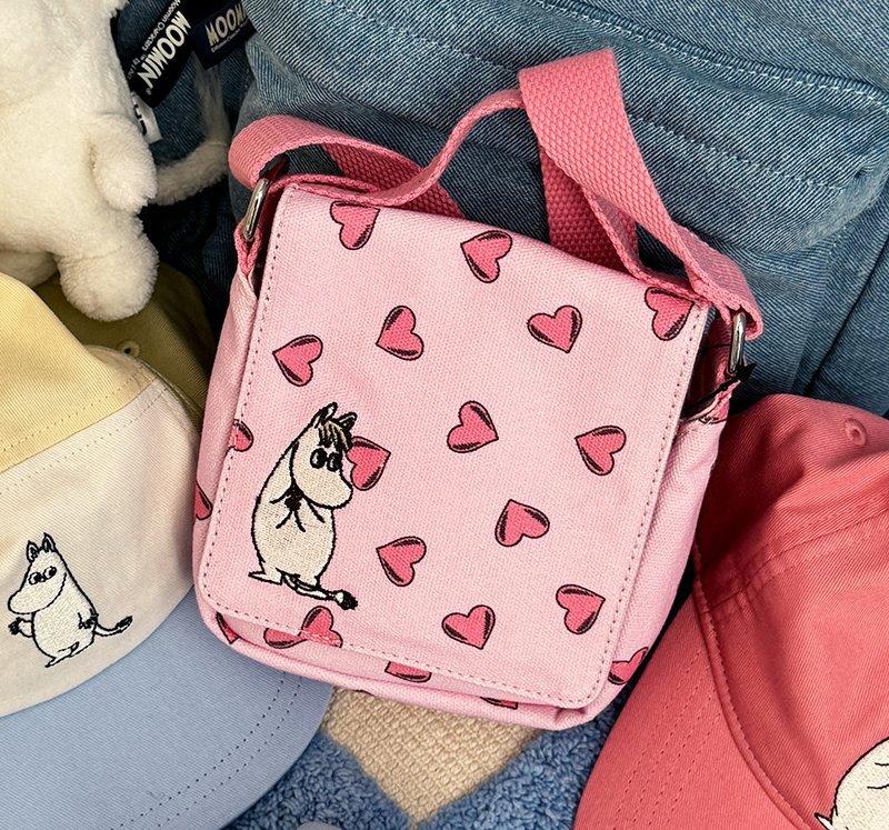 Close-up of a pink bag with Moomin print and hearts.