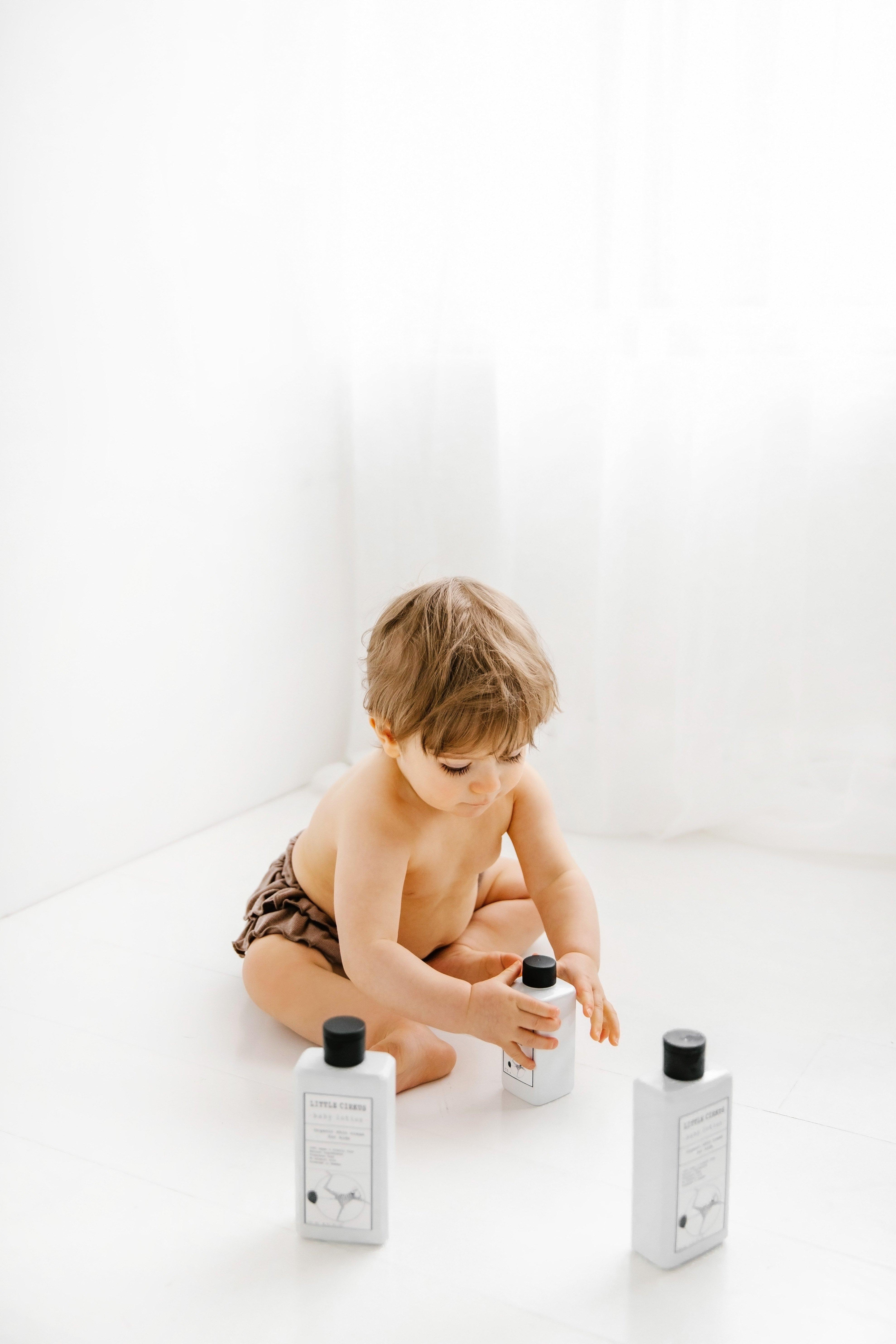 Et ungt barn med flasker av Little Cirkus-produkter