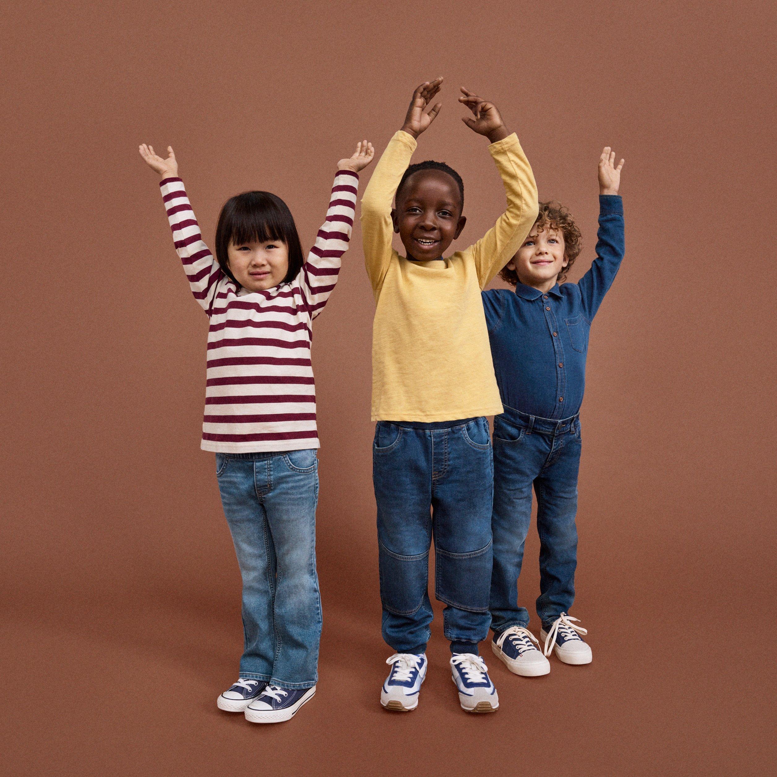  Three mischievous preschool children are having fun against a brown background.