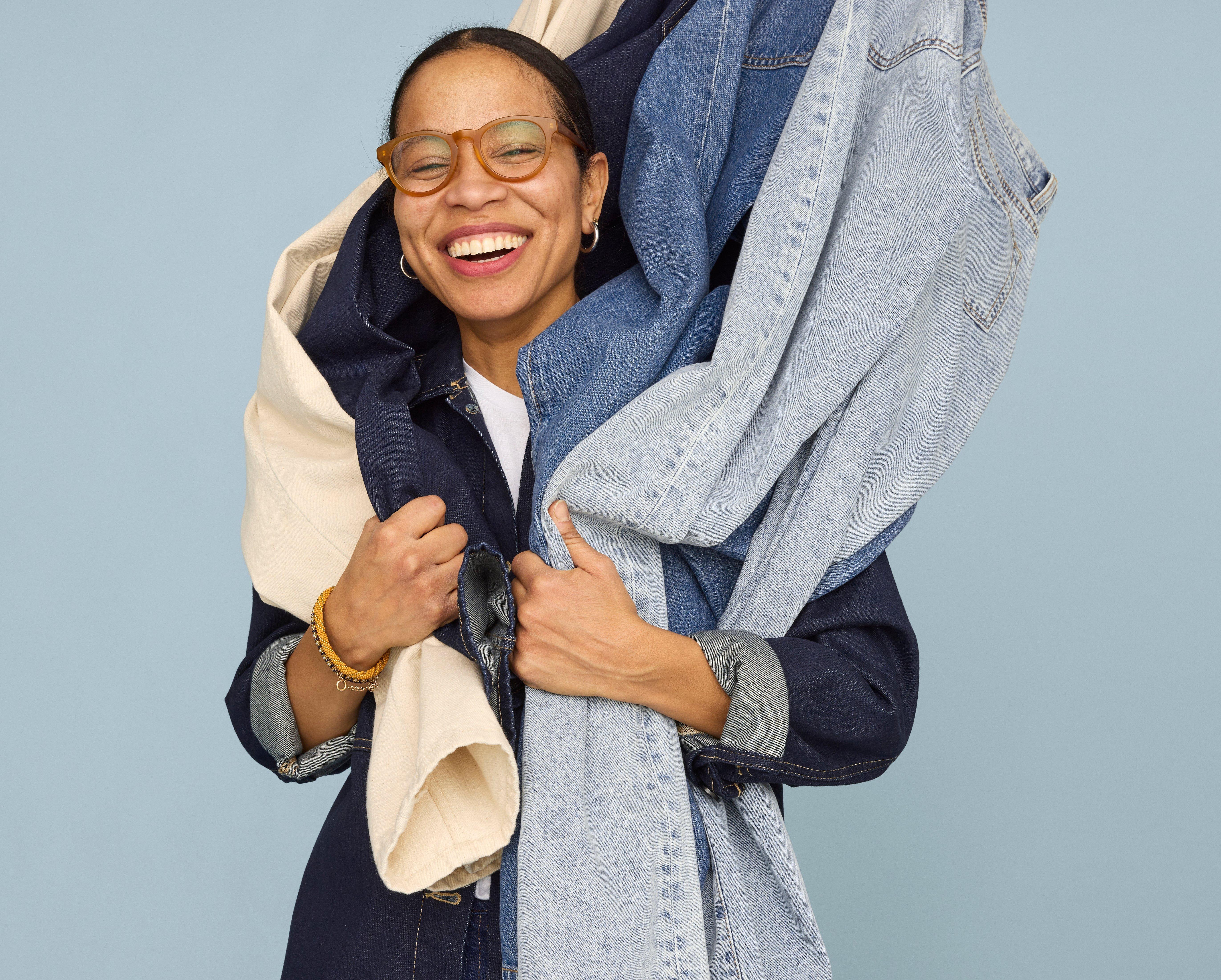 A picture of Suzana Lopes with different denim fabrics around her.