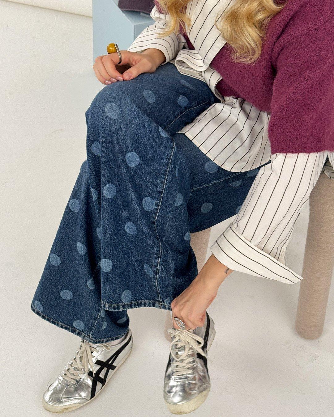 Detailný záber na pár džínsov s bodkami.