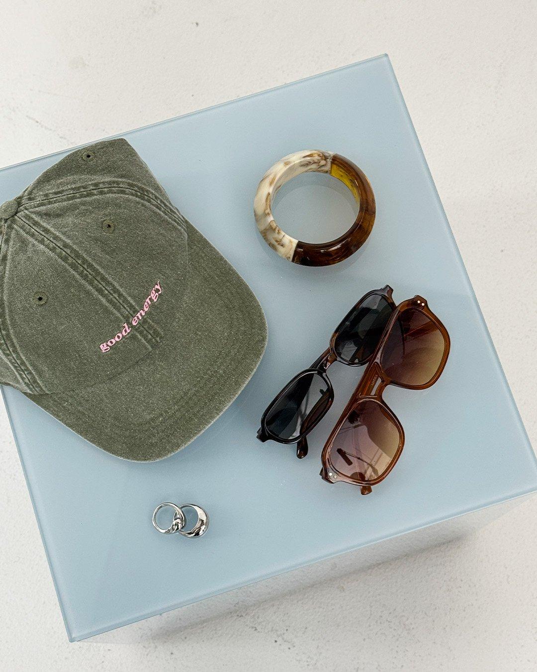 A close-up on a bag, a cap and some jewellery.
