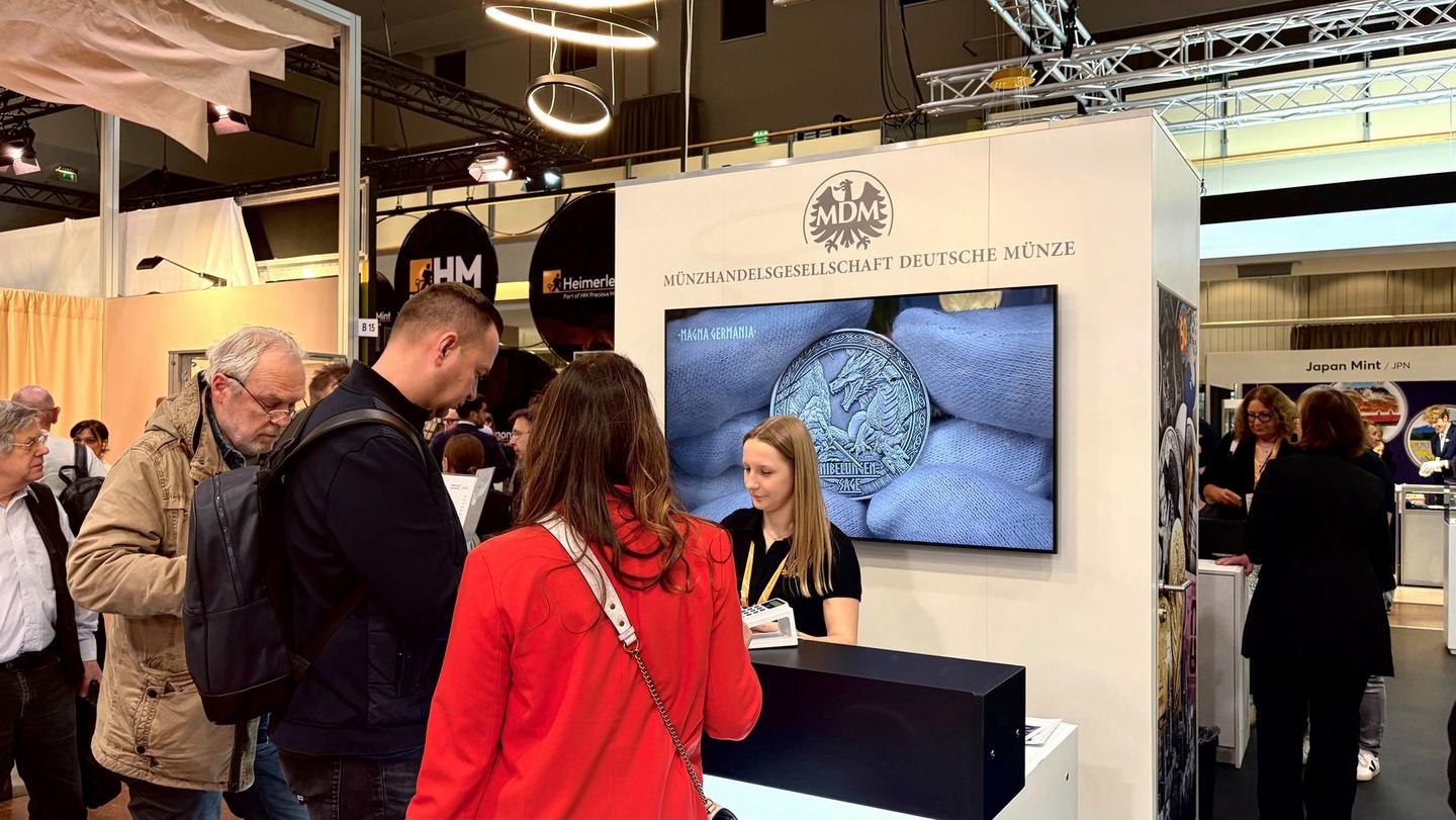 Beratungsgespräch am MDM-Messestand mit Bildschirmpräsentation und interessierten Messebesuchern