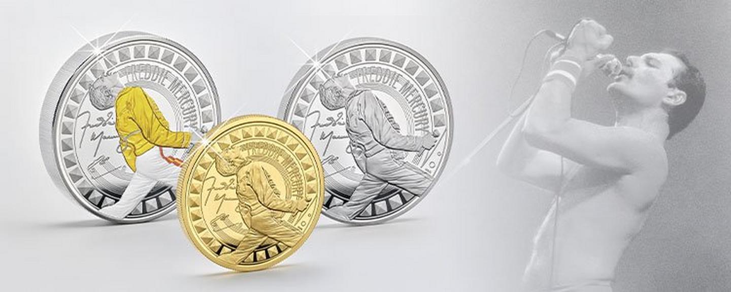Gedenkmünzen mit Freddie Mercury in Silber, Farbe und Gold, daneben ein Konzertfoto des Sängers im Hintergrund.