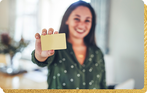 Woman holding up a gold card.