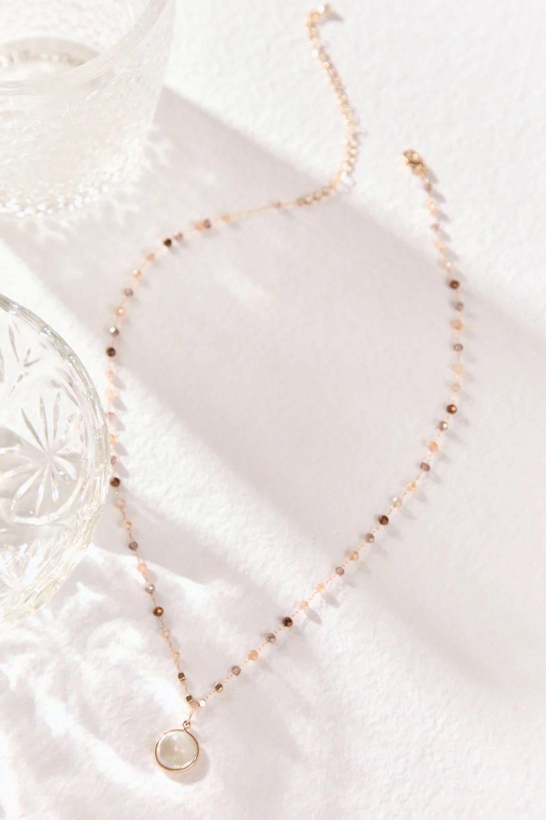 gold necklace with glass beads and a coin pearl pendant