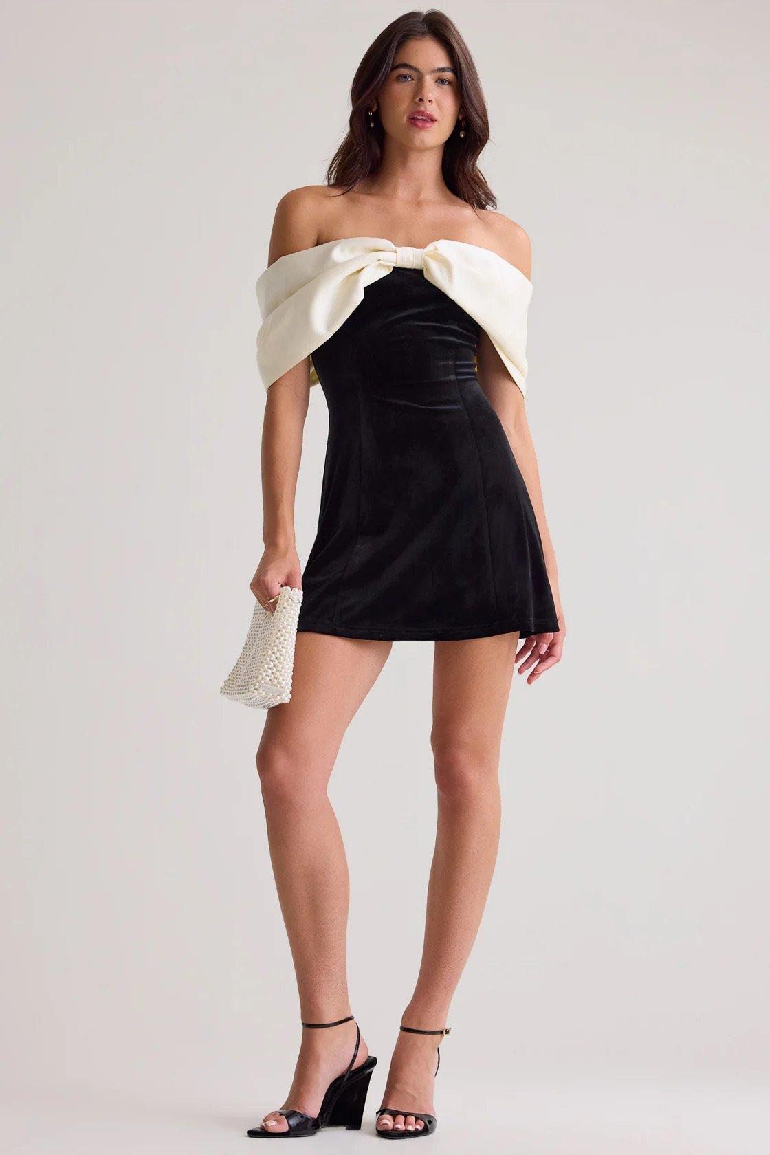 black velvet mini dress with white bow of the shoulder