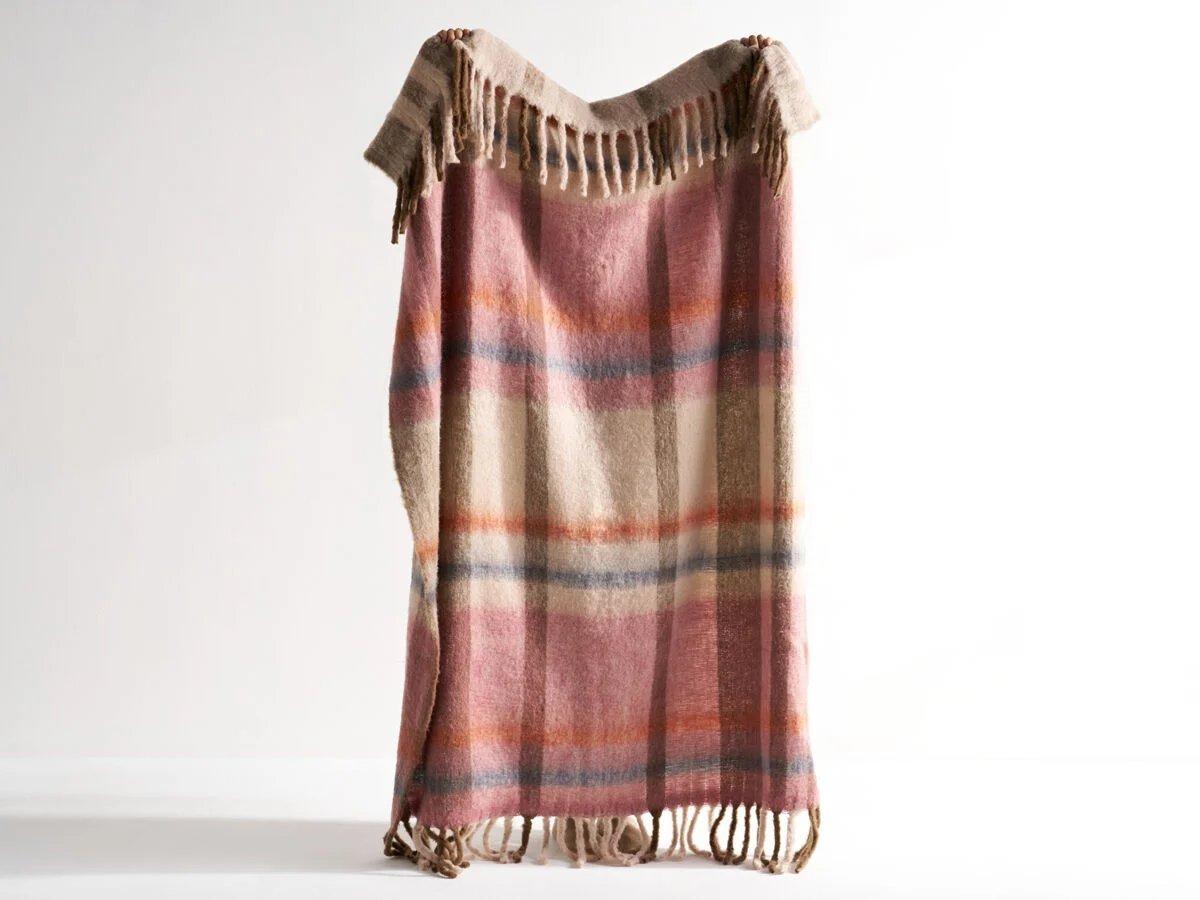 Red, orange, beige, and blue colored plaid throw