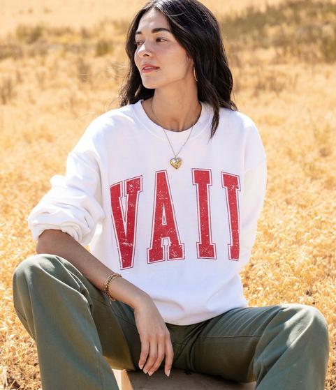 Woman wearing a white sweatshirt saying Vail in red