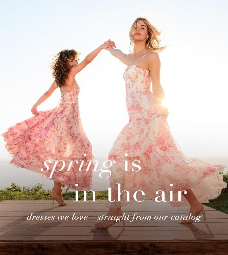 Two girls wearing floral pink dresses.