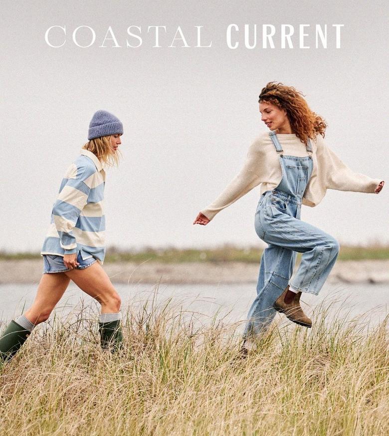 two girls wearing blue and denim running through a field