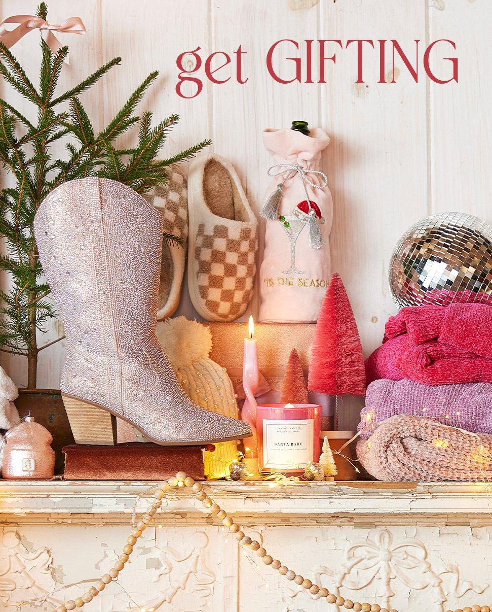 Various gifts on a mantle including sweaters, candles, slippers and ornaments