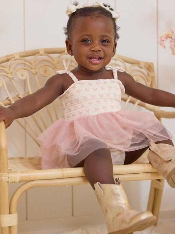 little girl wearing a pink and white tutu dress and cowboy boots