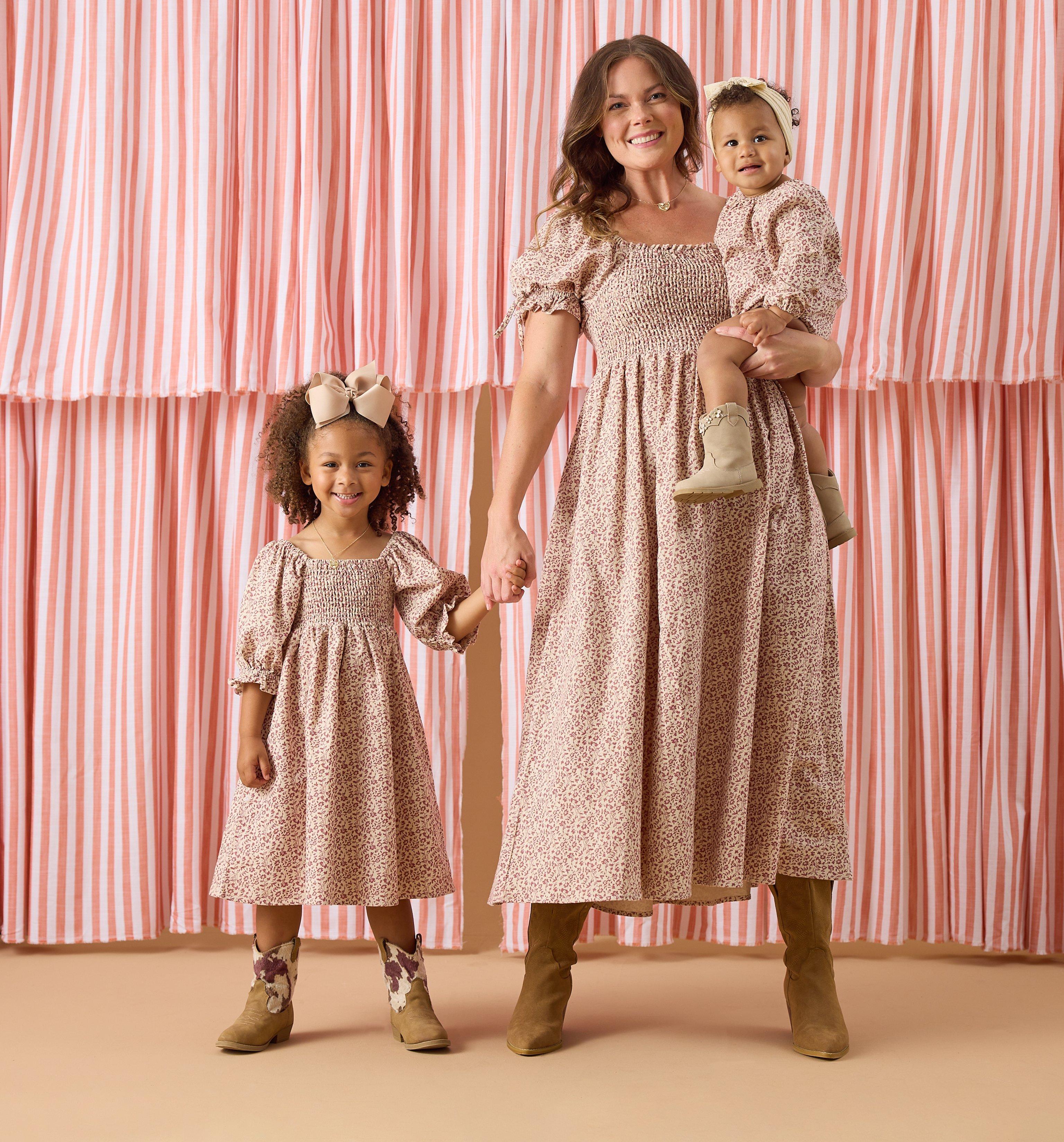 Mom, Toddler, and baby girl wearing matching brown dresses.