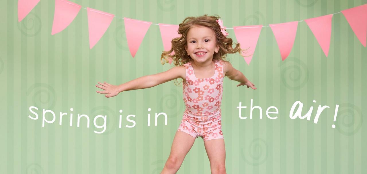 Little girl wearing pink floral athletic one piece.