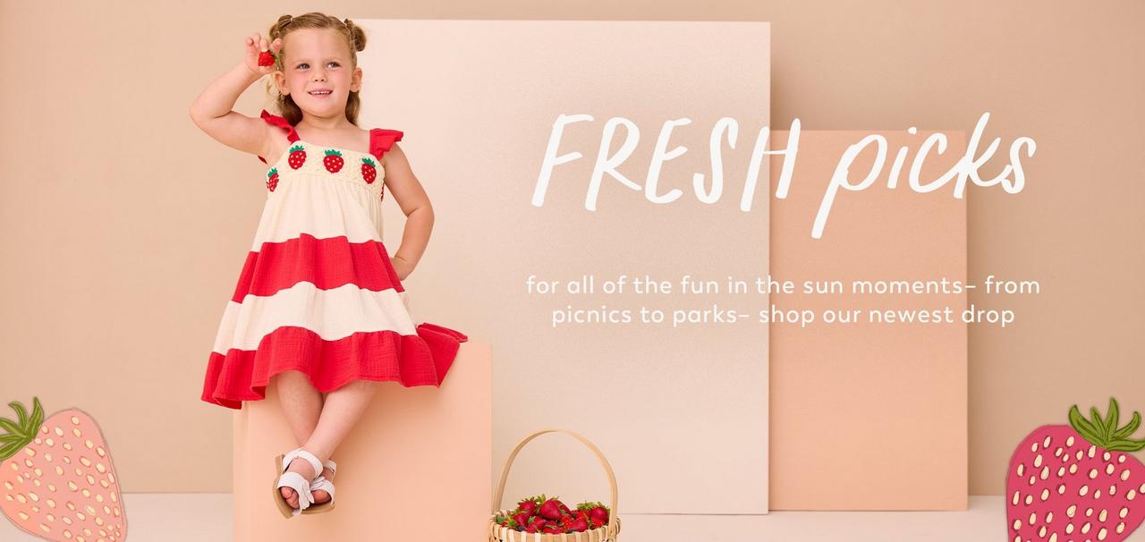 Little girl wearing red and white dress with strawberries on it.