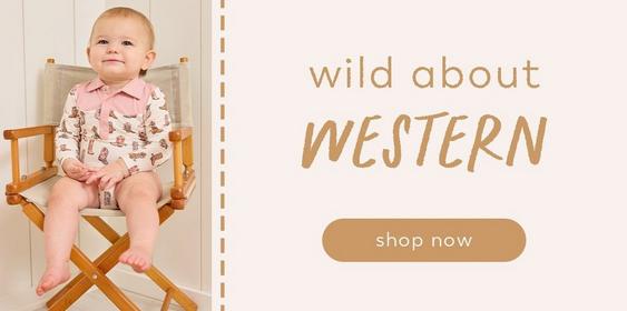 Little girl wearing a cowboy boots print onesie